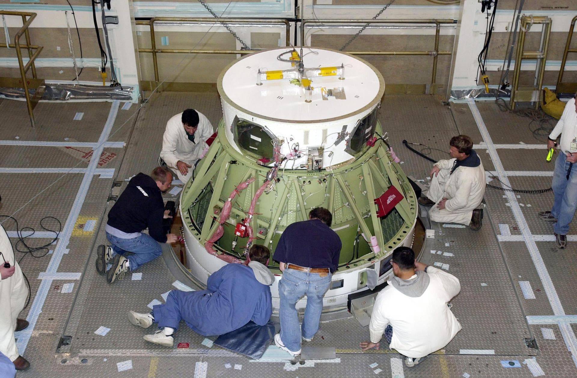VANDENBERG AFB, CALIF. -  - Inside the gantry on the SLC-2 launch pad, workers check the fitting on the second stage of a Delta II rocket mated with the first stage, below. The Delta II will launch th