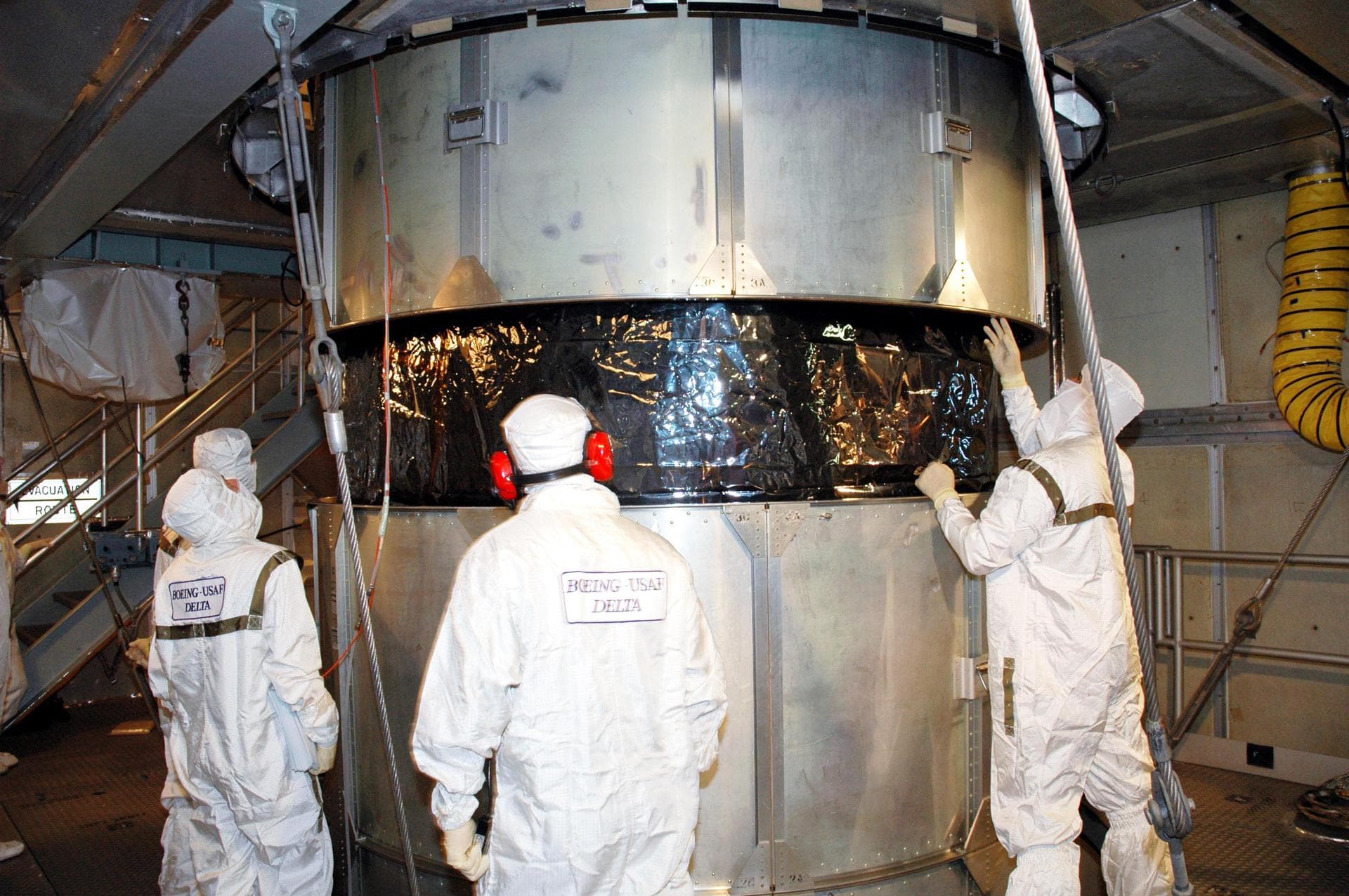 KENNEDY SPACE CENTER, FLA. -  Inside the mobile service tower on Launch Pad 17-A , Cape Canaveral Air Force Station, Fla., Boeing technicians observe the lifting of the transport canister surrounding 