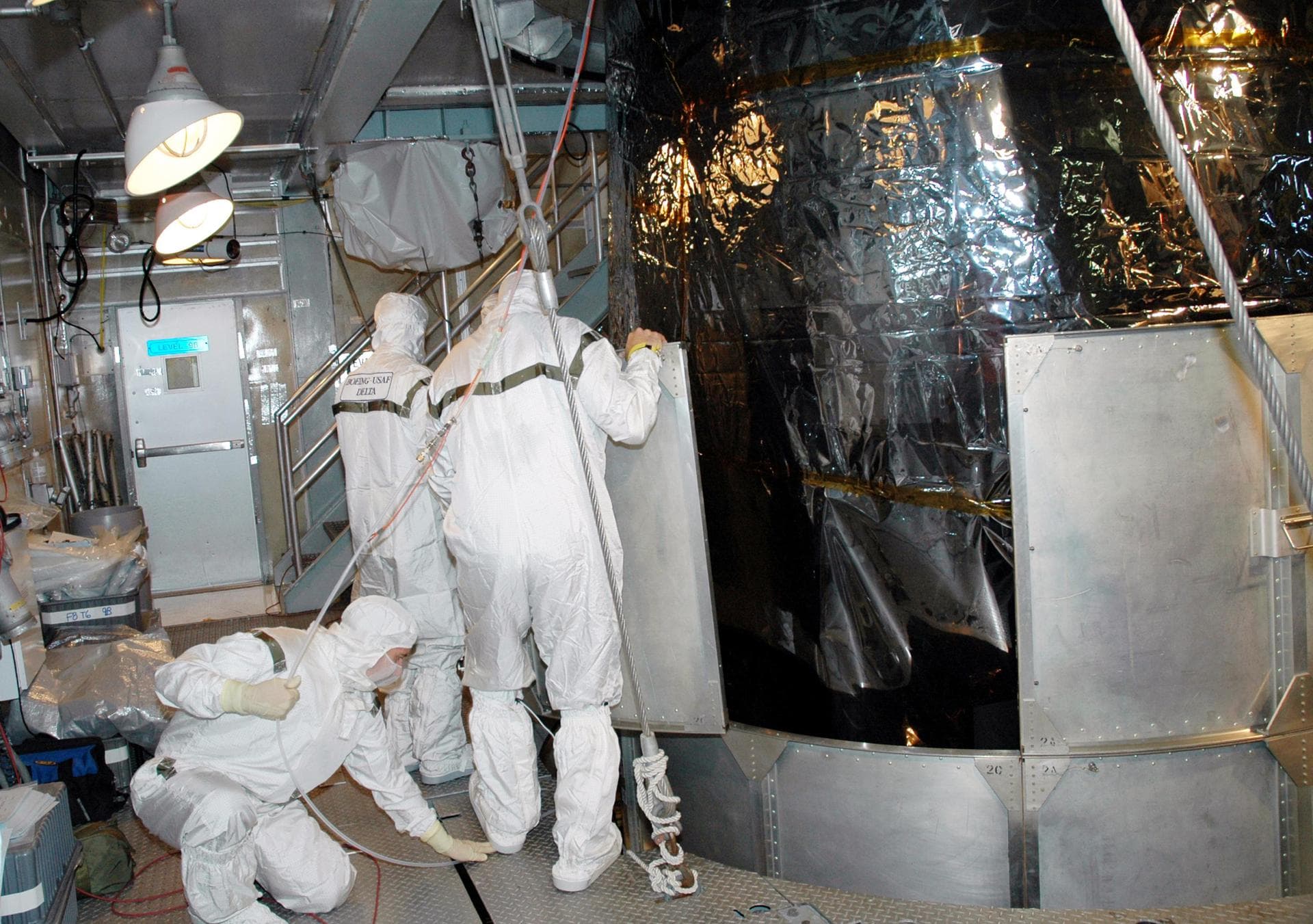 KENNEDY SPACE CENTER, FLA. -  Inside the mobile service tower on Launch Pad 17-A , Cape Canaveral Air Force Station, Fla., Boeing technicians remove the lower portion of the transport canister from th