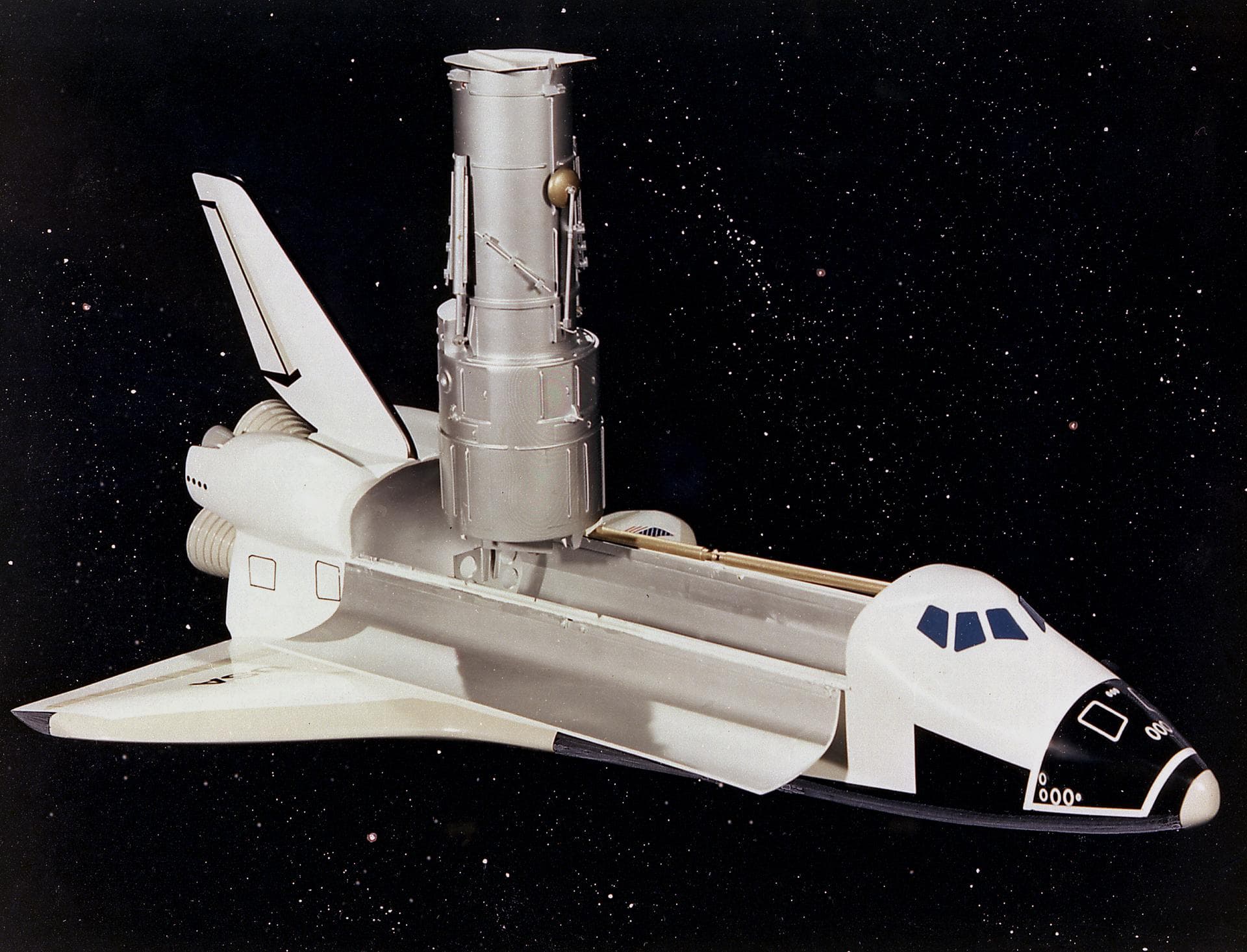 This artist's concept depicts the Hubble Space Telescope (HST) being raised to a vertical position in the cargo bay of the Space Shuttle orbiter. The HST is the product of a partnership between NASA, 