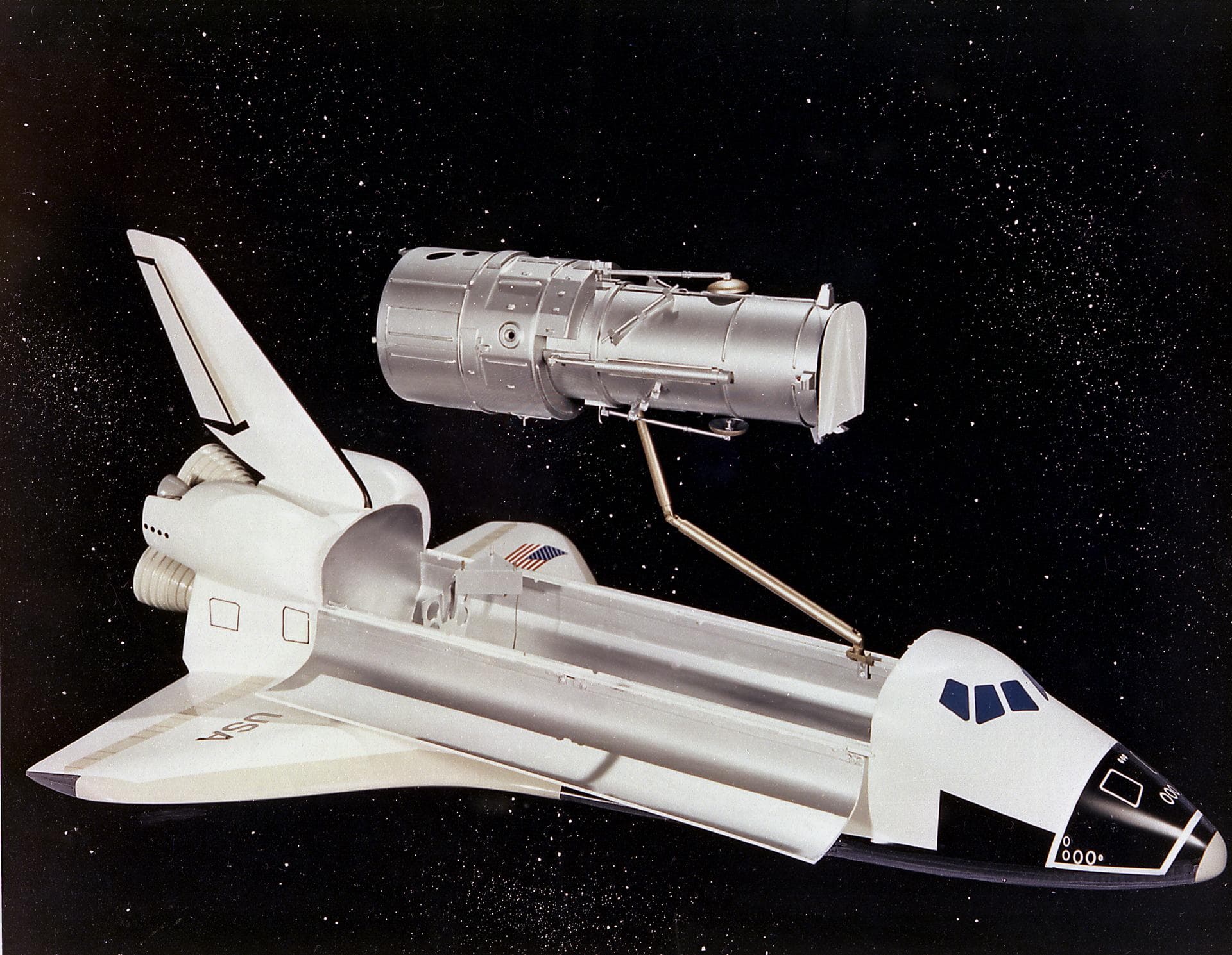 This artist's concept depicts the Hubble Space Telescope (HST) being positioned for release from the Space Shuttle orbiter by the Remote Manipulator System (RMS). The HST is the product of a partnersh