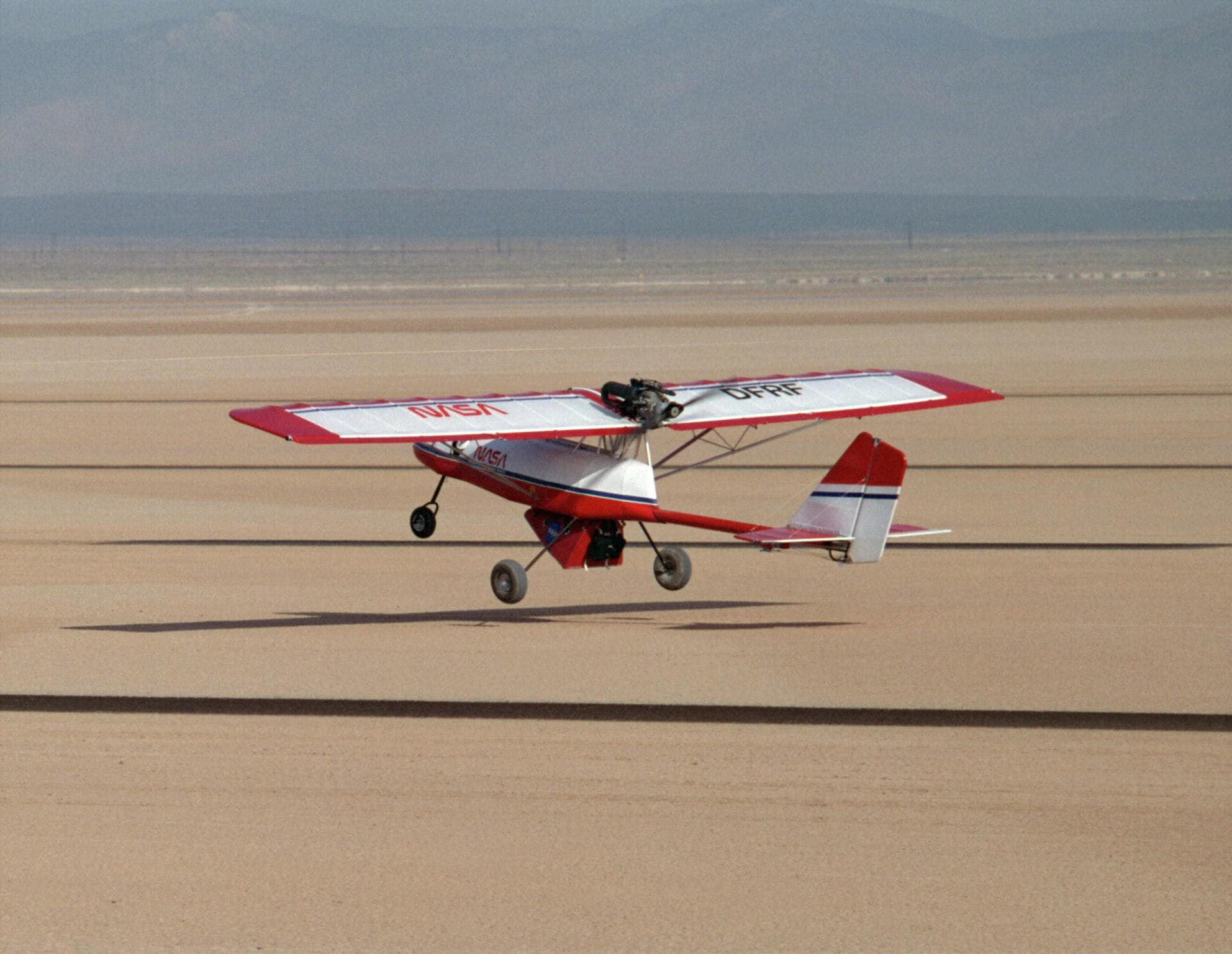 A Rans S-12 remotely piloted "mothership" takes off from a lakebed runway carrying a Spacewedge research model during 1992 flight tests. The Spacewedge was lauched in flight from the Rans S-12 aircraf