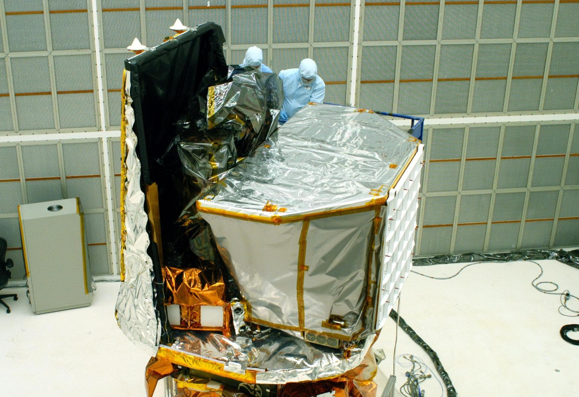 KENNEDY SPACE CENTER, FLA. - In Hangar AE at Cape Canaveral Air Force Station, Spectrum Astro workers remove the final pieces of protective cover on the Swift spacecraft.  Swift is a first-of-its-kind