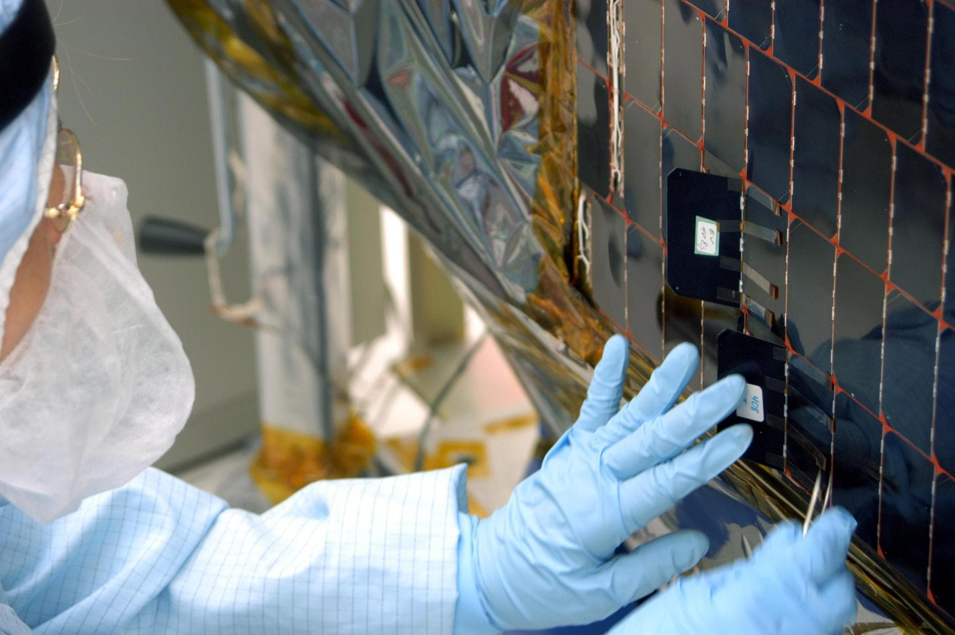 KENNEDY SPACE CENTER, FLA. -  In the clean room at NASA’s Hangar AE on Cape Canaveral Air Force Station (CCAFS), a Spectrolab technician, Anna Herrera,  places a new solar cell on the Swift spacecraft