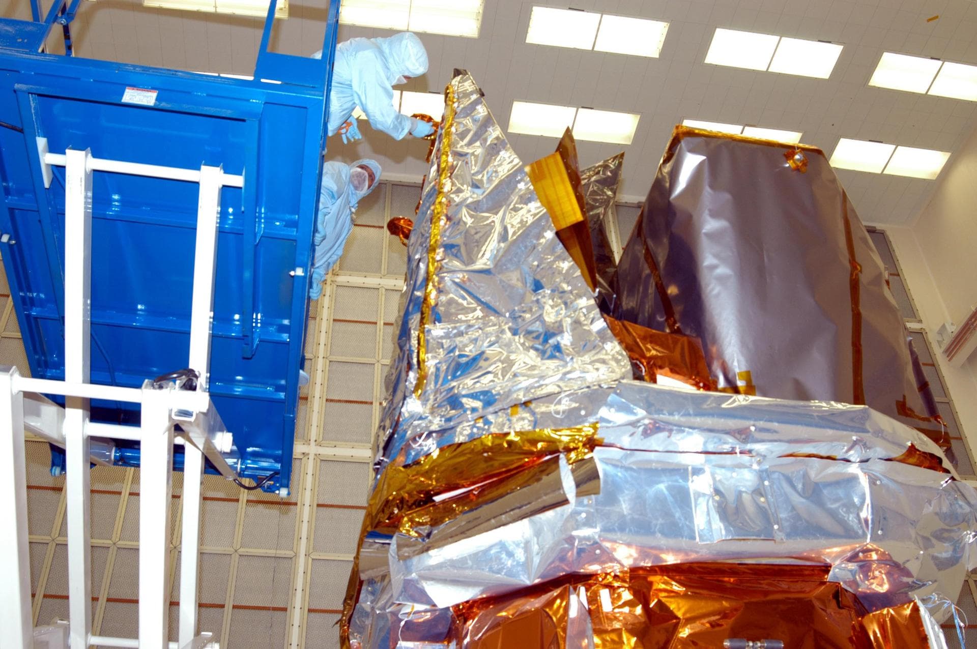 KENNEDY SPACE CENTER, FLA. - In Hangar AE at Cape Canaveral Air Force Station, technicians perform blanket closeouts on the Swift spacecraft.  The blankets provide thermal stability during the mission