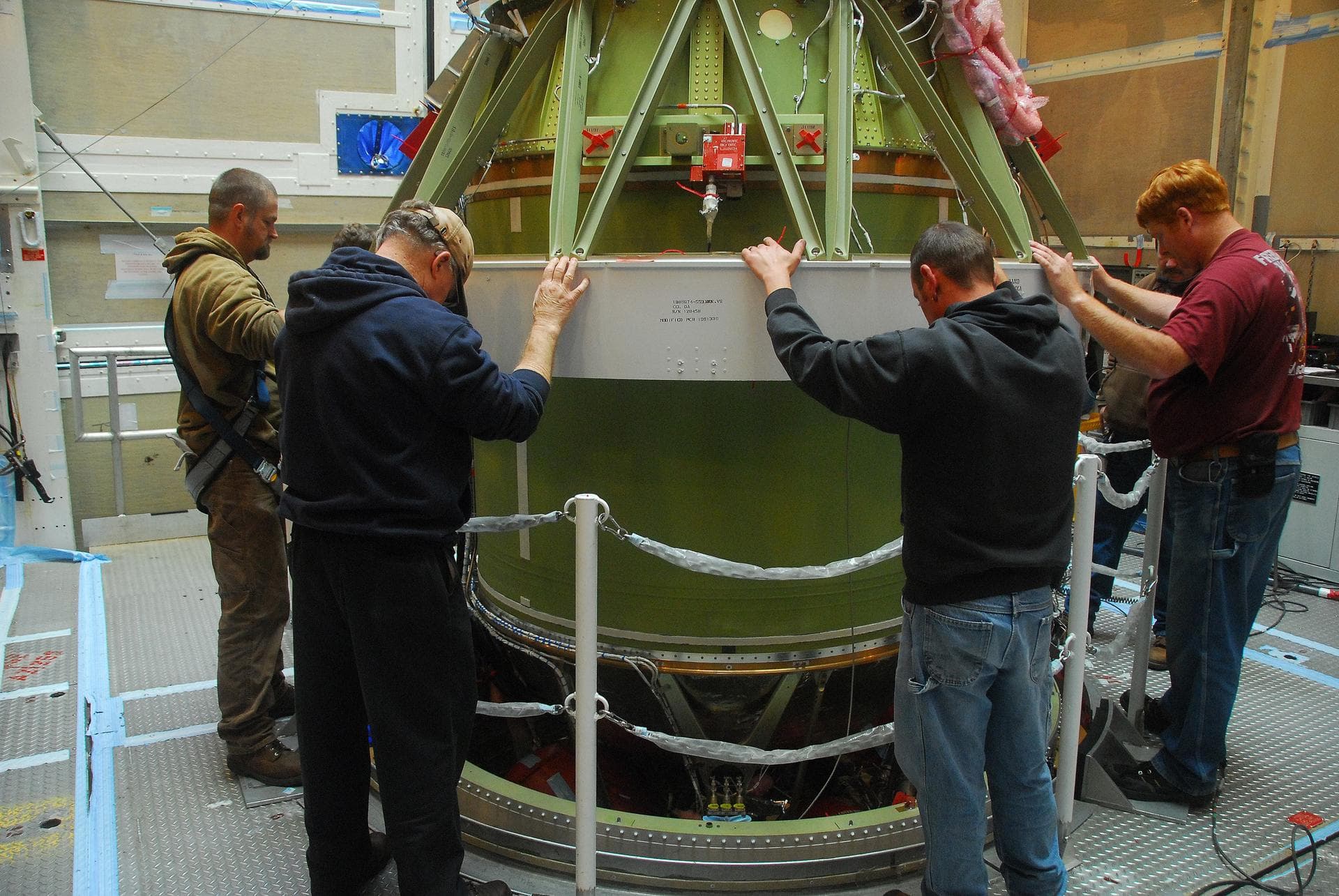 VANDENBERG AIR FORCE BASE, Calif. -- Technicians secure the AJ10 engine for the second stage of the United Launch Alliance Delta II rocket on a work stand at NASA’s Space Launch Complex-2 service towe