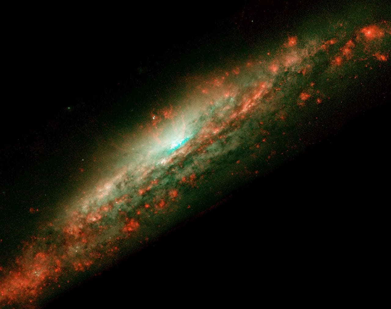 A lumpy bubble of hot gas rises from a cauldron of glowing matter in a distant galaxy, as seen by NASA Hubble Space Telescope.
