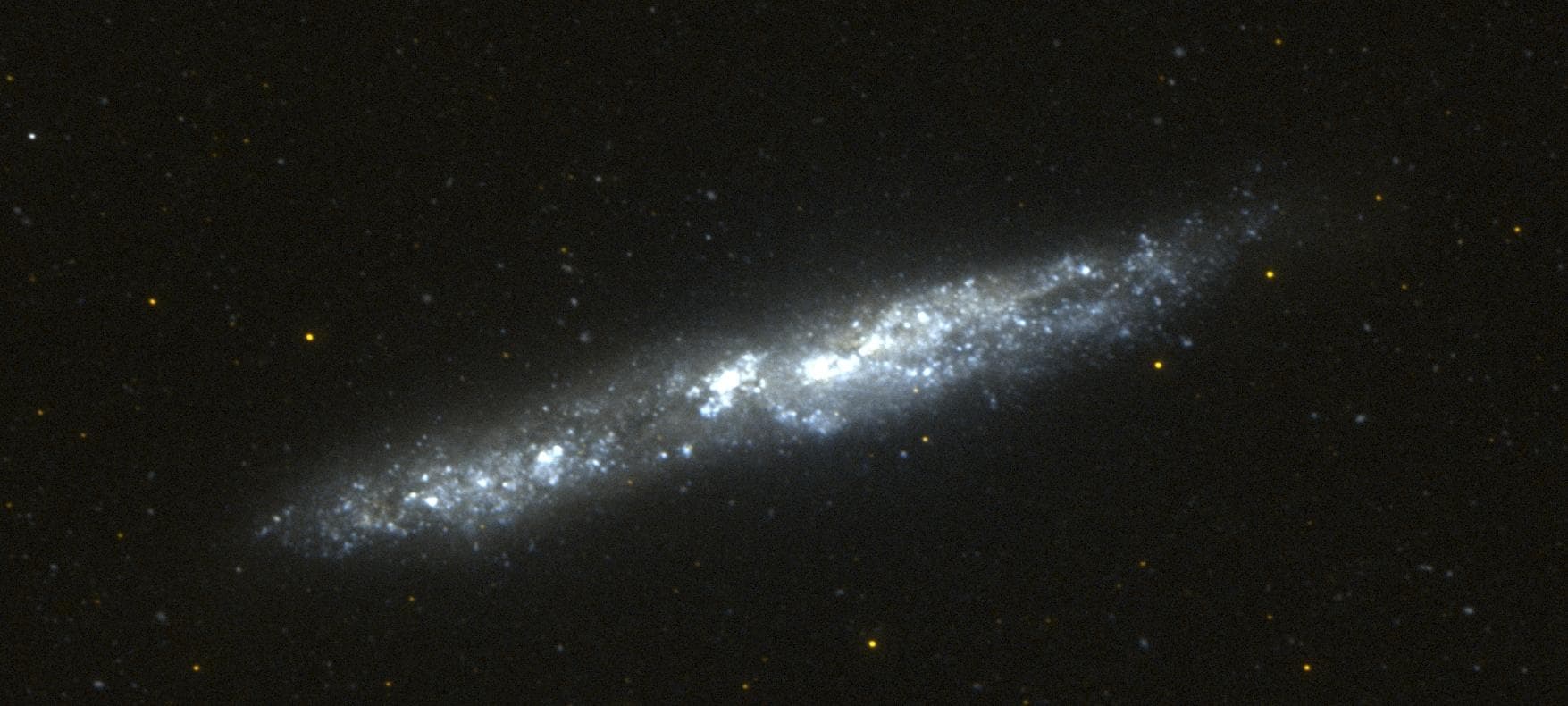 This image of the nearby edge-on spiral galaxy NGC 55 was taken by Galaxy Evolution Explorer on September 14, 2003, during 2 orbits. This galaxy lies 5.4 million light years from our Milky Way galaxy