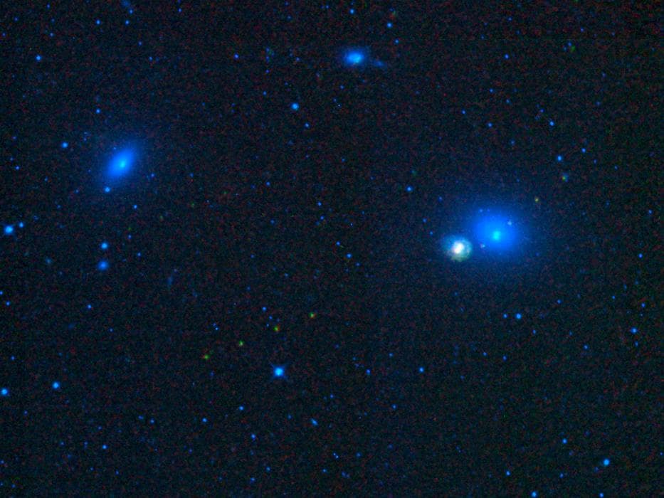 This image from NASA Wide-field Infrared Survey Explorer, shows four galaxies in the Virgo cluster: Messier 59, Messier 60, NGC 4647, and NGC 4638. It also shows the tracks of three asteroids, which a