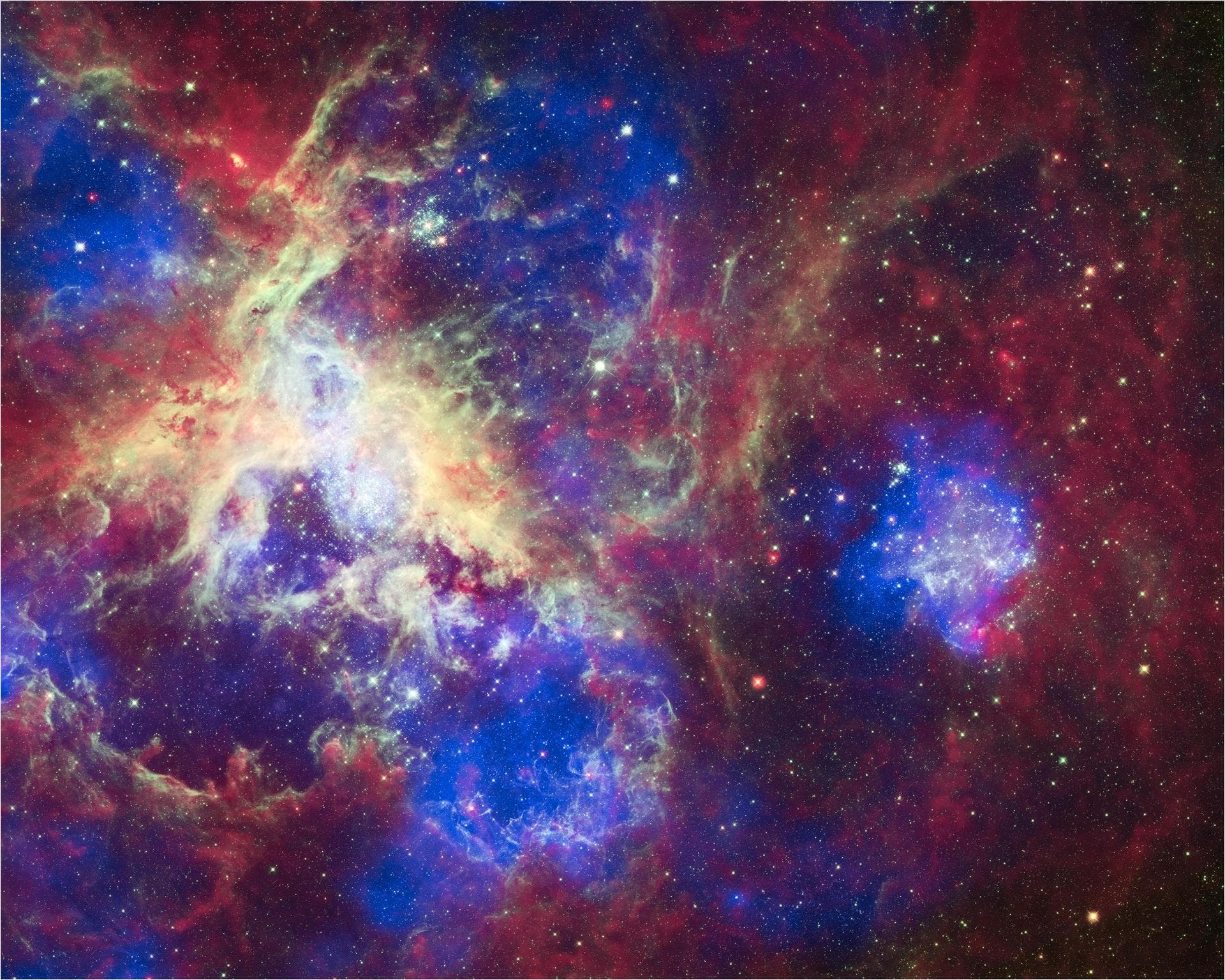 This composite of 30 Doradus, the Tarantula Nebula, contains data from Chandra blue, Hubble green, and Spitzer red. Located in the Large Magellanic Cloud, the Tarantula Nebula is one of the largest st