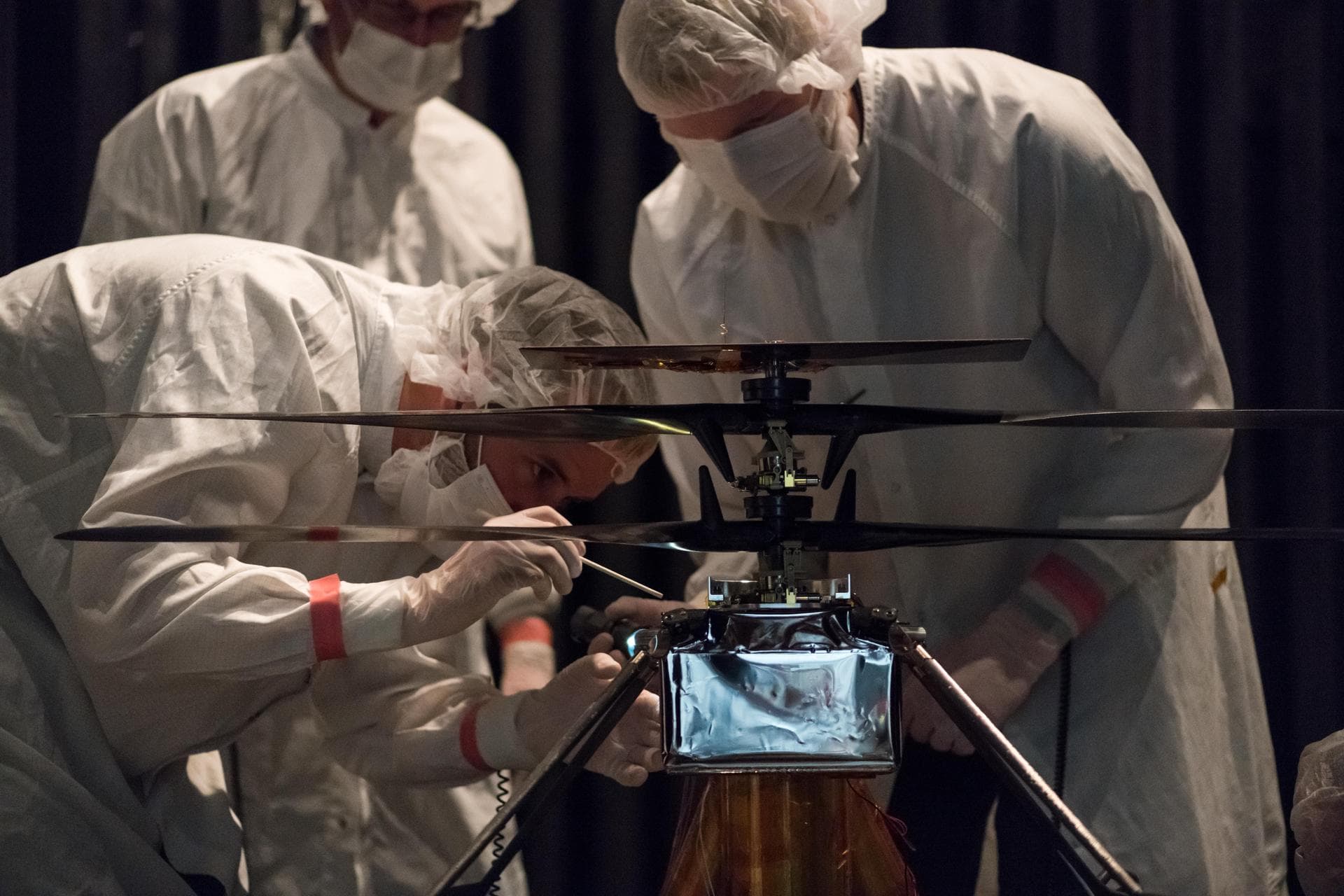 Members of NASA's Mars Helicopter team attach a thermal film enclosure to the fuselage of the flight model (the actual vehicle going to the Red Planet). The image was taken on Feb. 1, 2019, inside the