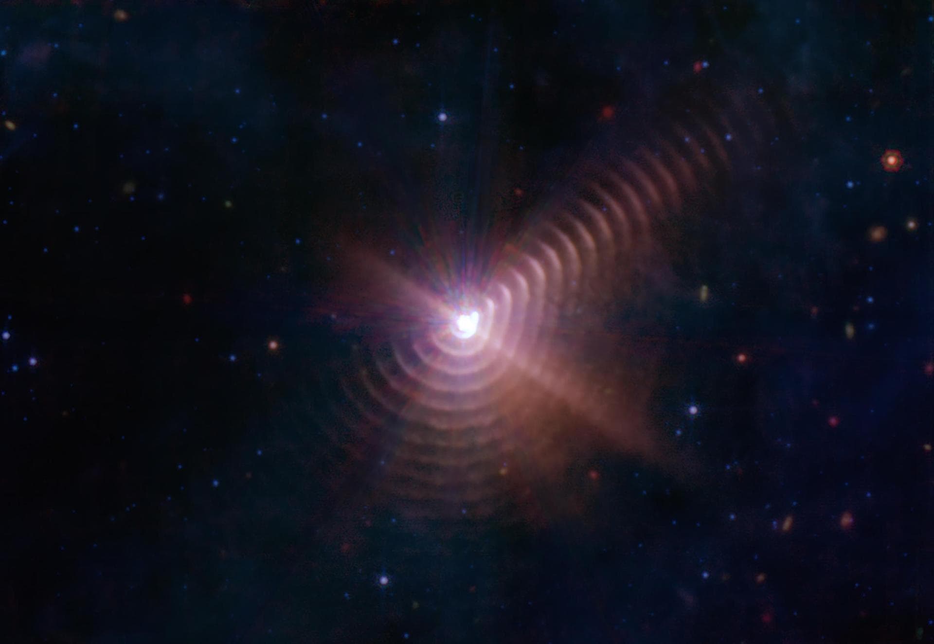 This image from NASA's James Webb Space Telescope reveals at least 17 concentric dust rings emanating from a pair of stars orbiting one another. Located just over 5,000 light-years from Earth, the sys
