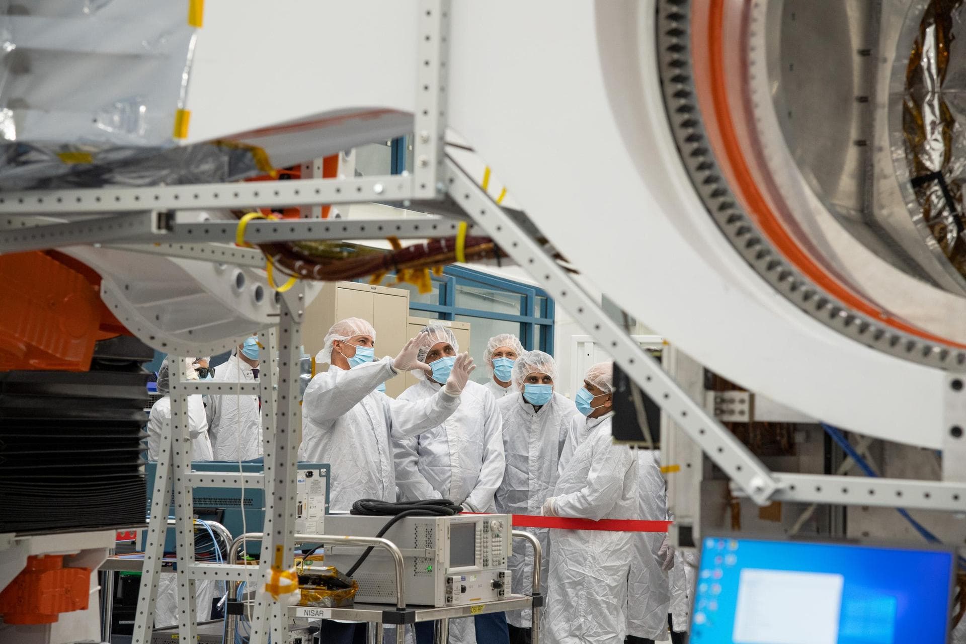 NASA's NISAR Project Manager Phil Barela (with hands raised) speaks with Indian Space Research Organisation Chairman S. Somanath about the NASA-ISRO Synthetic Aperture Radar (NISAR) science instrument