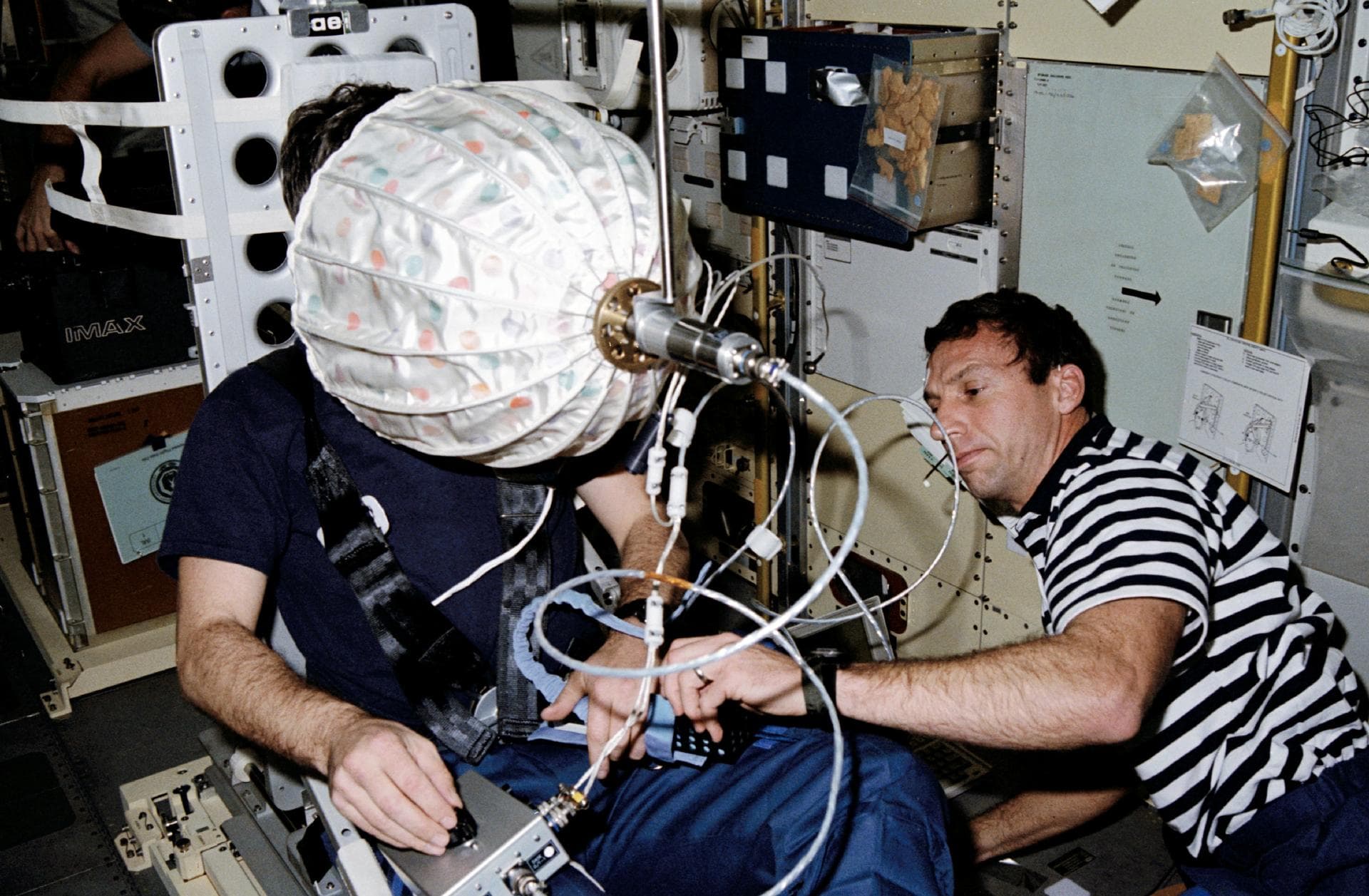STS042-203-024 (22-30 Jan. 1992) --- Astronaut David C. Hilmers (right), STS-42 mission specialist, assists European Space Agency (ESA) payload specialist Ulf Merbold with the visual stimulator experi
