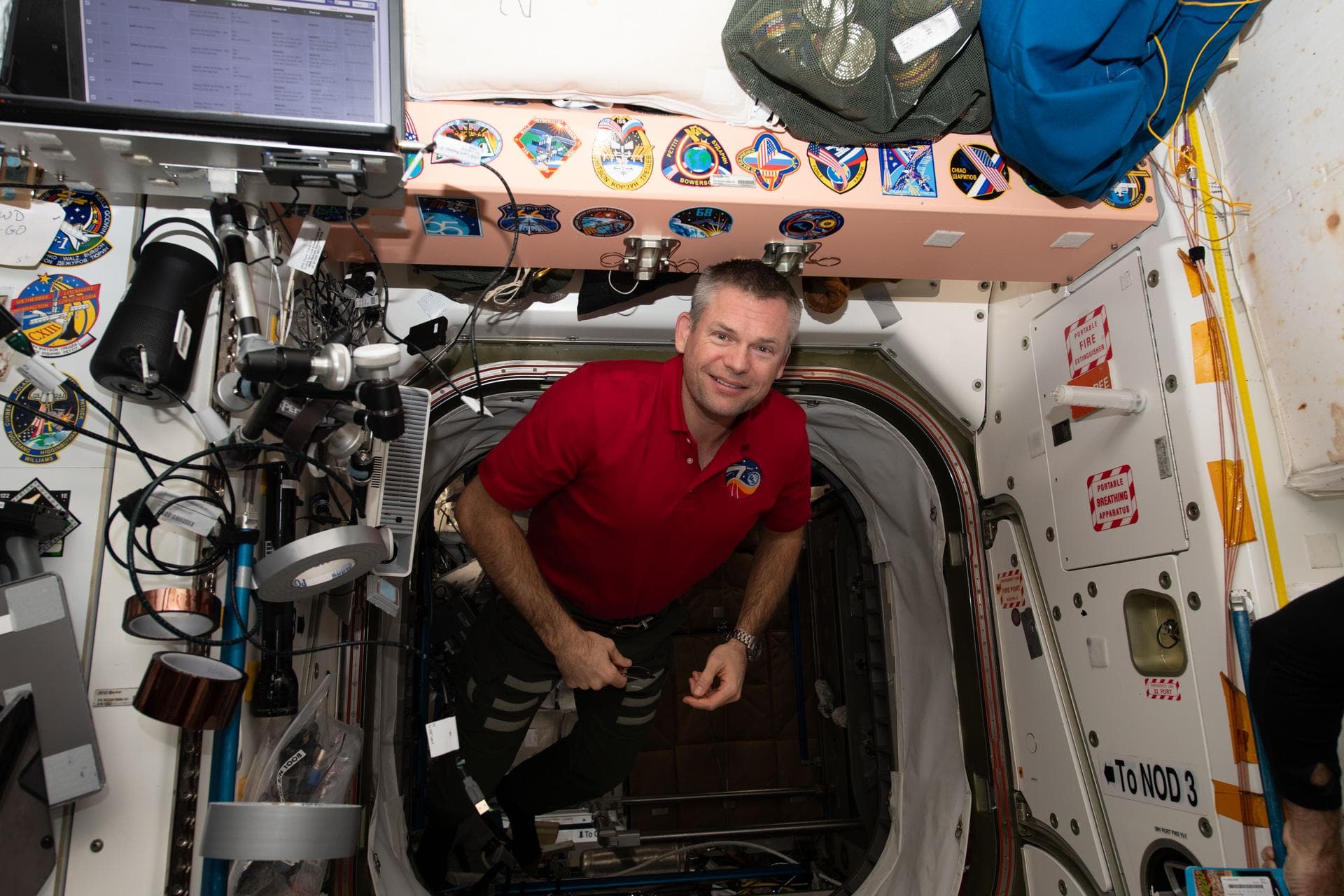 iss070e092708 (Feb. 7, 2024) --- ESA (European Space Agency) astronaut and Expedition 70 Commander Andreas Mogensen smiles for a portrait as he maneuvers in the vestibule in between the Unity and Tran