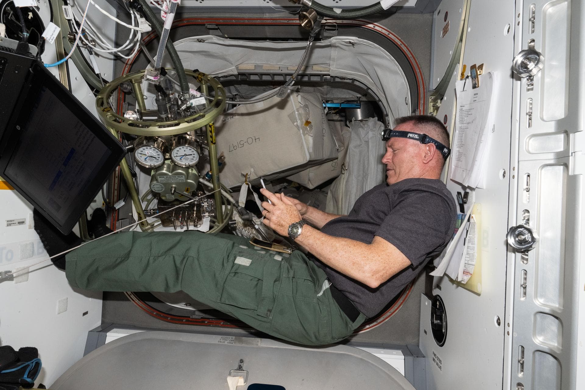 iss071e318564 (July 10, 2024) --- NASA astronaut and Boeing's Crew Flight Test Commander Butch Wilmore reviews procedures on a computer tablet for life support maintenance work aboard the Internationa