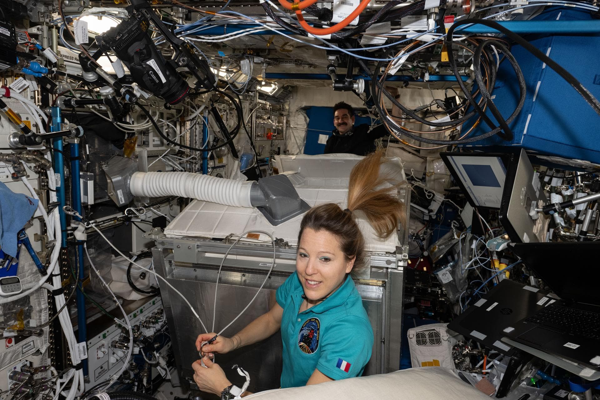 iss074e0792345 (June 7, 2026) --- Expedition 74 flight engineers Sophie Adenot of ESA (European Space Agency) and Jack Hathaway of NASA (background) are pictured inside the International Space Station
