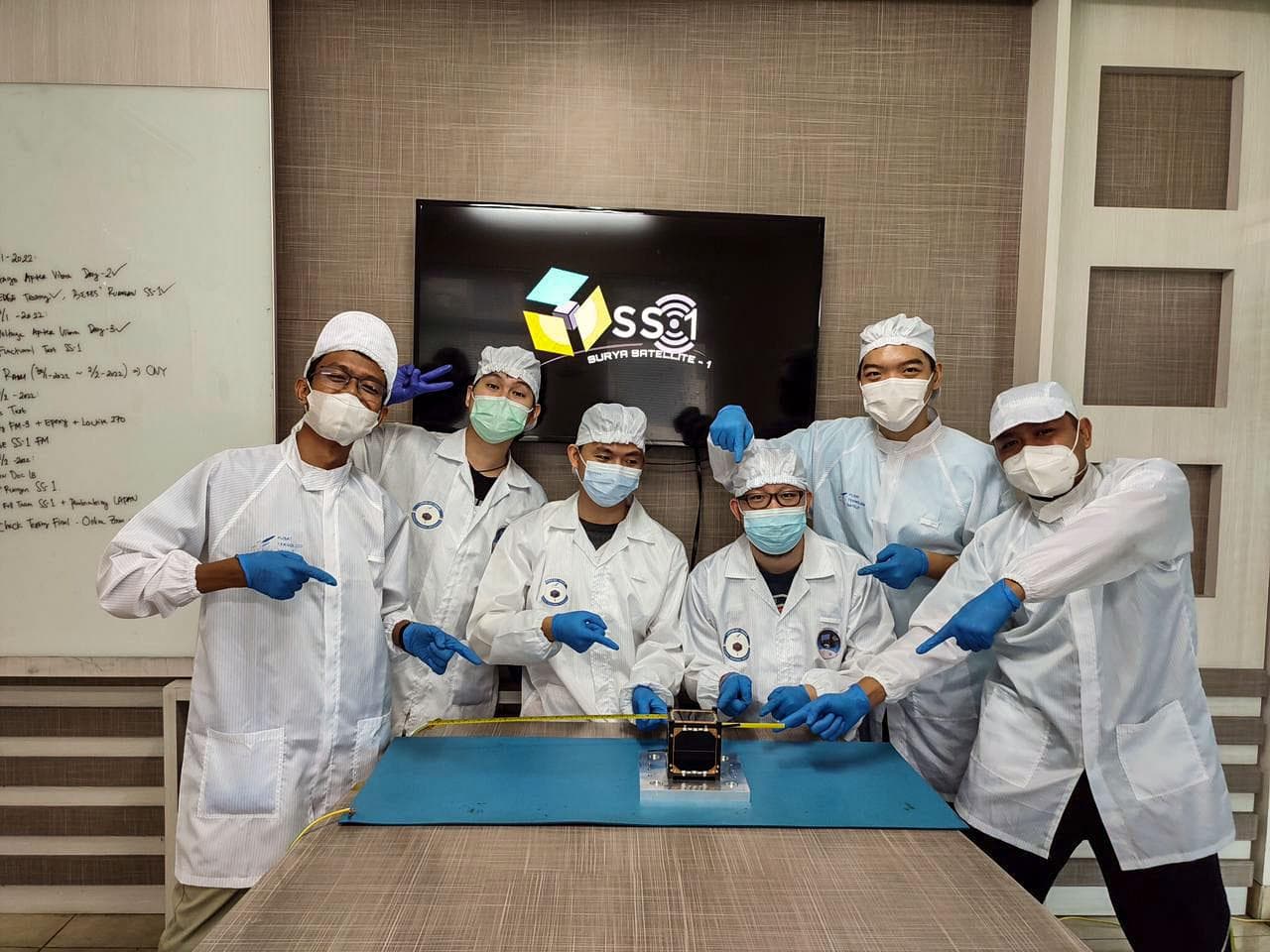 jsc2022e068260 (11/1/2021) --- The Surya Satellite-1 and its Developer Team After Deployment Testing, shown left to right: Zulfa, Hery, Setra, Roberto, Suhan, Afiq.  The Surya Satellite-1 (SS-1) is th