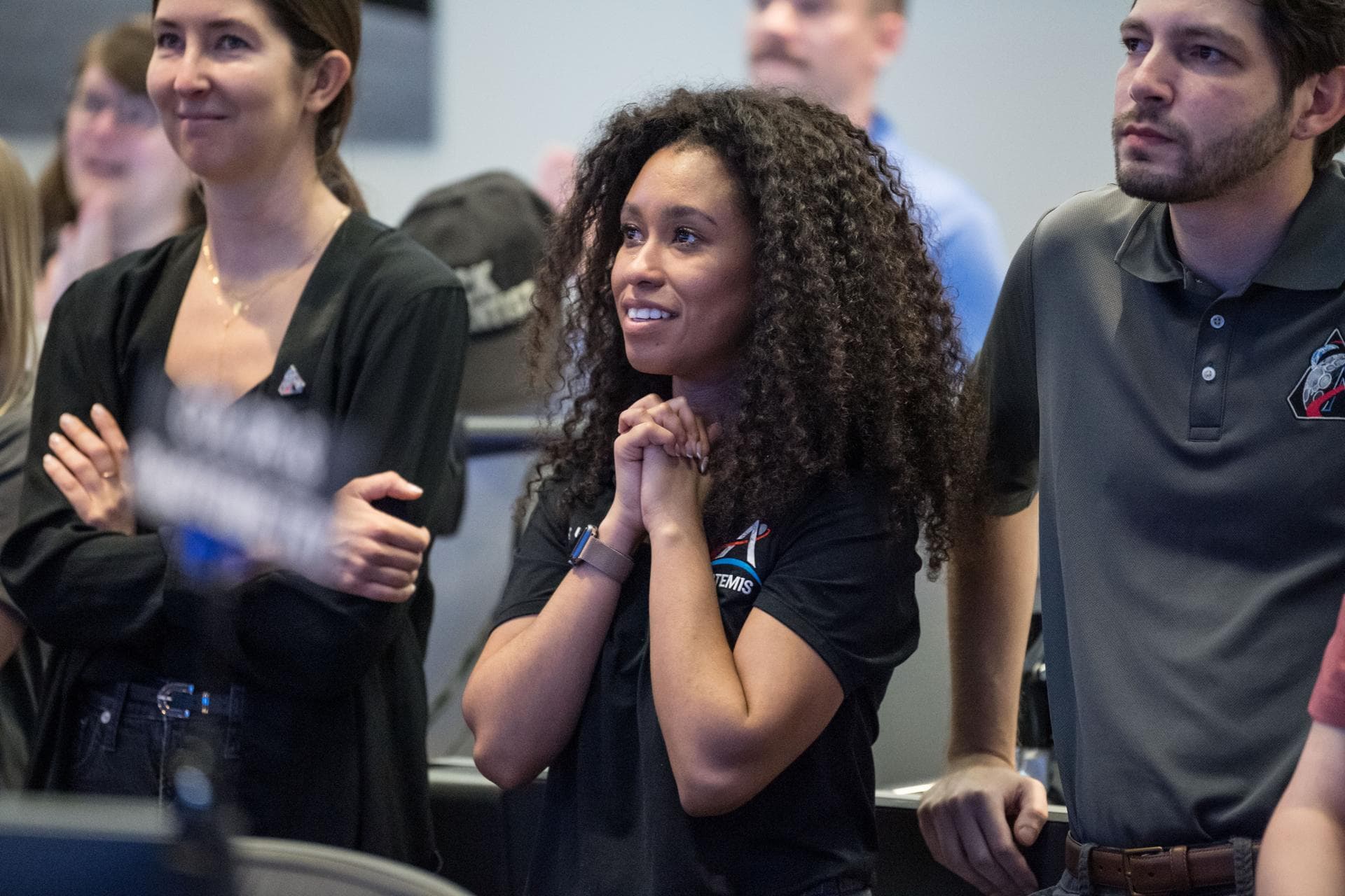 Members of the Artemis lunar science team, from left, Ariel Deutsch, Amber Turner, and Wilfredo Garcia-Lopez, watch the Artemis II launch from the Science Evaluation Room (SER) in Mission Control at J