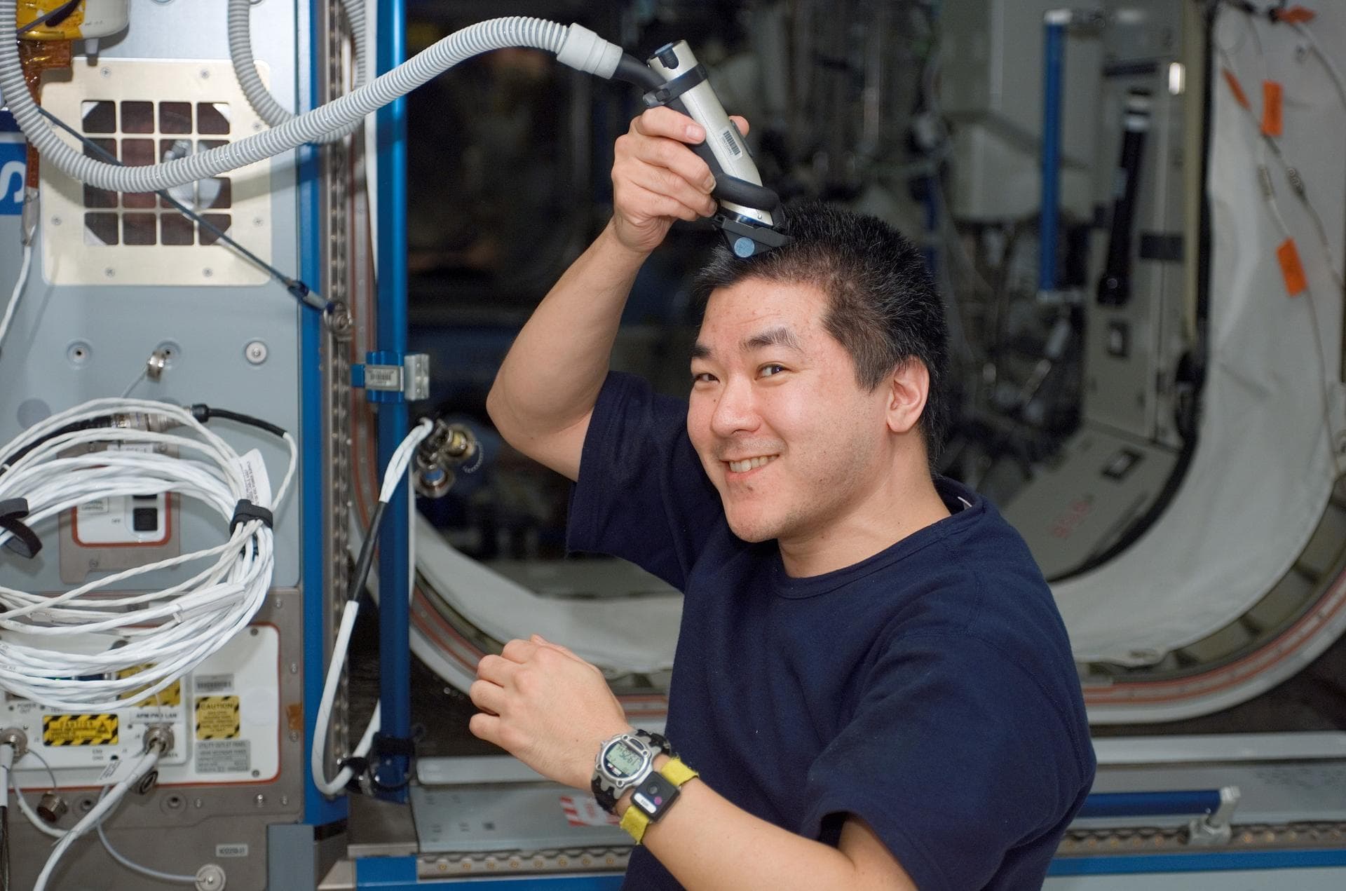 S122-E-007645 (10 Feb. 2008) --- Astronaut Daniel Tani, Expedition 16 flight engineer, trims his hair in the Harmony node of the International Space Station while Space Shuttle Atlantis is docked with
