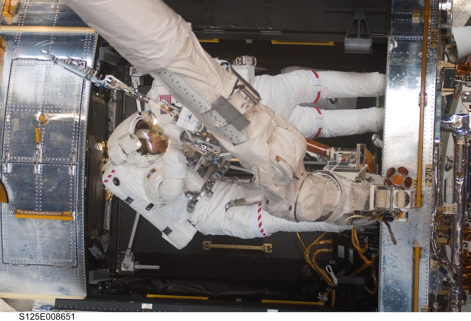 S125-E-008651 (17 May 2009) --- Astronauts Michael Good (bottom) and Mike Massimino, both STS-125 mission specialists, participate in the mission?s fourth session of extravehicular activity (EVA) as w