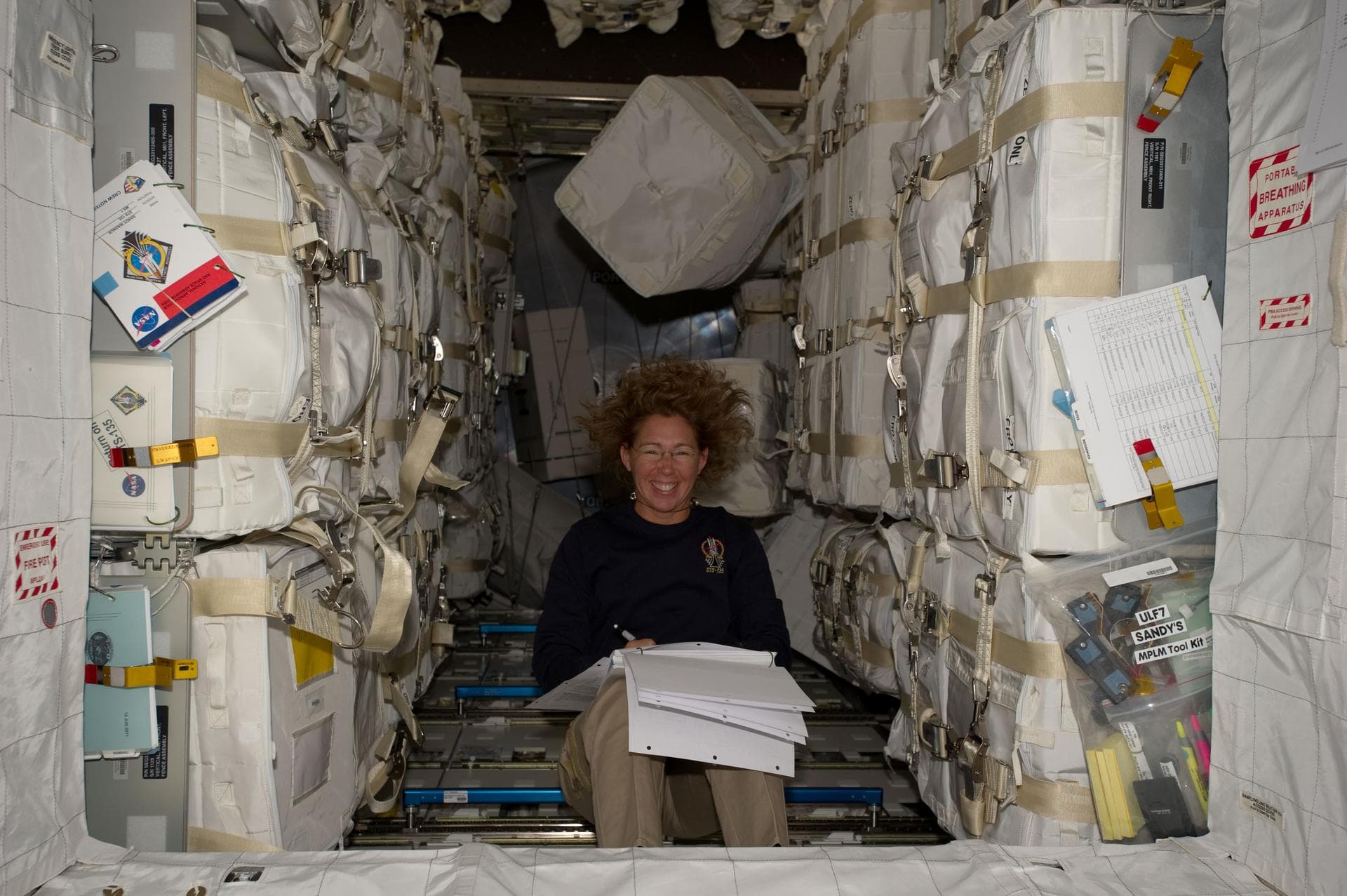 S135-E-007478  (12 July 2011) --- Surrounded by supplies and spare parts in the Raffaello multi-purpose logistics module, NASA astronaut Sandy Magnus continues her role as "load master" for the joint 