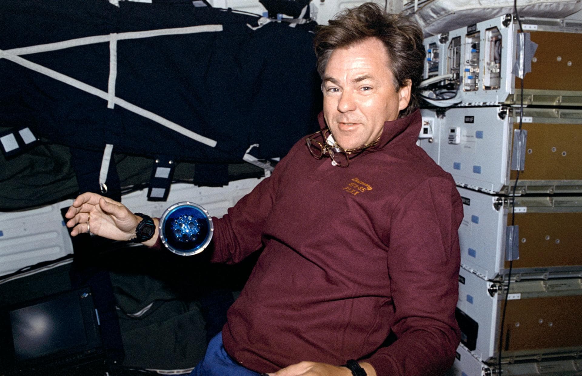 STS085-351-005 (7 - 19 August 1997) --- Payload specialist Bjarni Tryggvason of the Canadian Space Agency (CSA) shows off the Microgravity Vibration Isolation Mount (MIM) fluid disk.  One of five flui