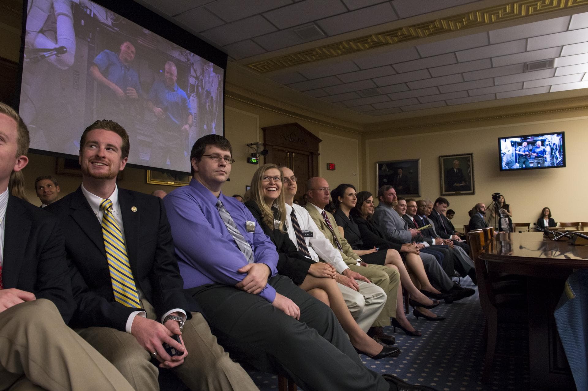 Audience members watch as astronauts Reid Wiseman and Steve Swanson answer questions posed to them by members of the Committee on Science, Space, and Technology at a full-committee event held Thursday