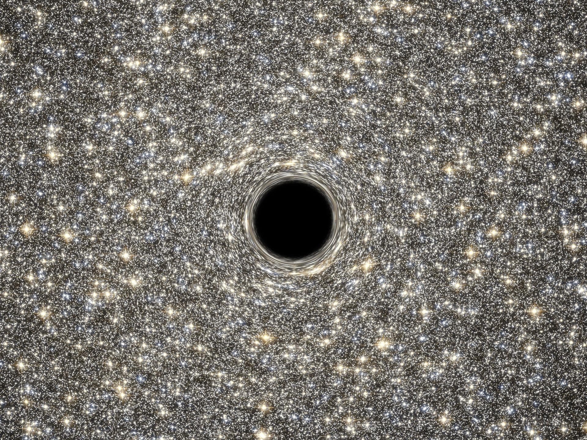 This is an illustration of a supermassive black hole, weighing as much as 21 million suns, located in the middle of the ultradense galaxy M60-UCD1. The dwarf galaxy is so dense that millions of stars