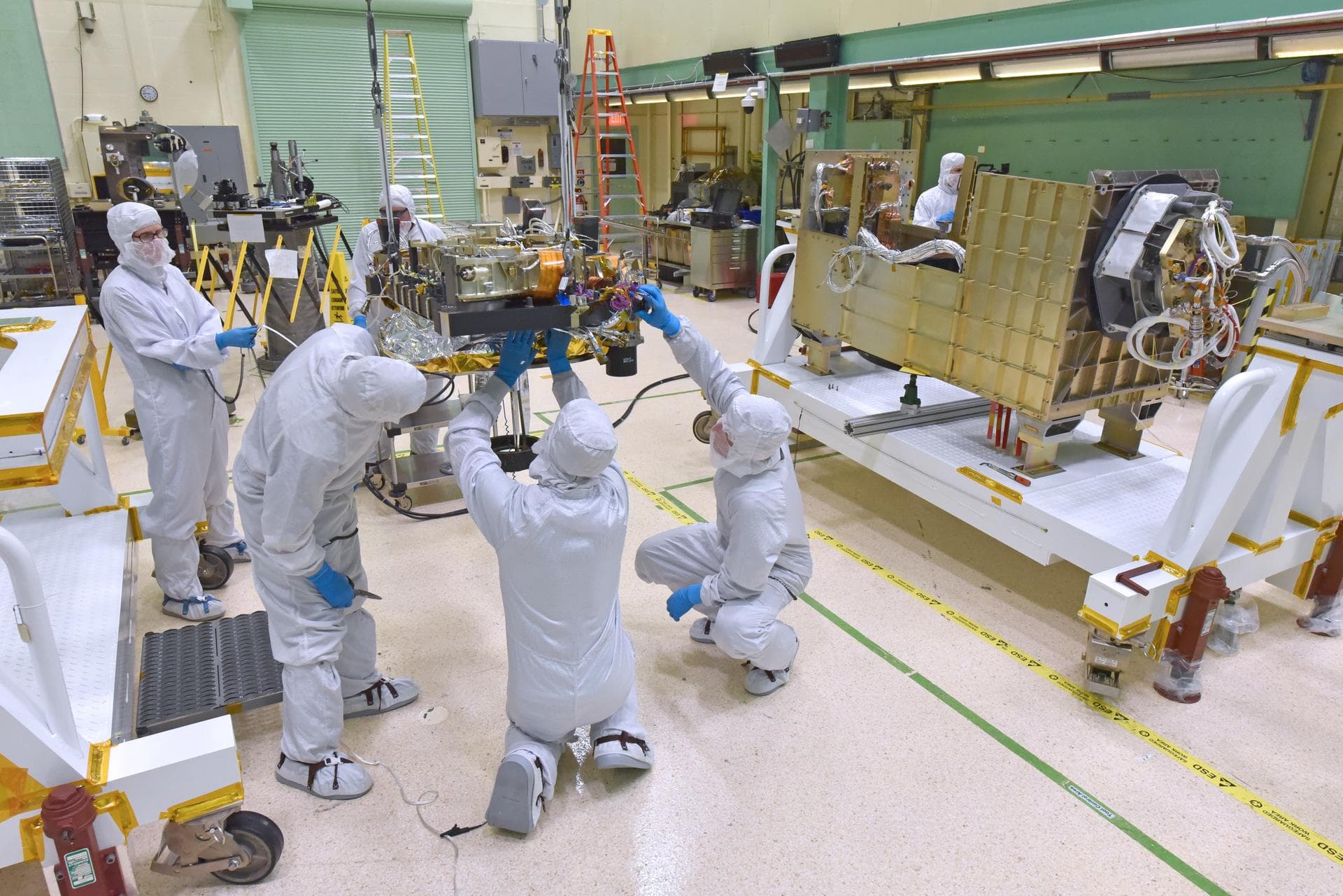 The Global Ecosystem Dynamics Investigation (GEDI) Optical Bench is suspended from the crane in the Spacecraft Checkout and Integration Area (SCA) clean room at Goddard Space Flight Center. Final clea