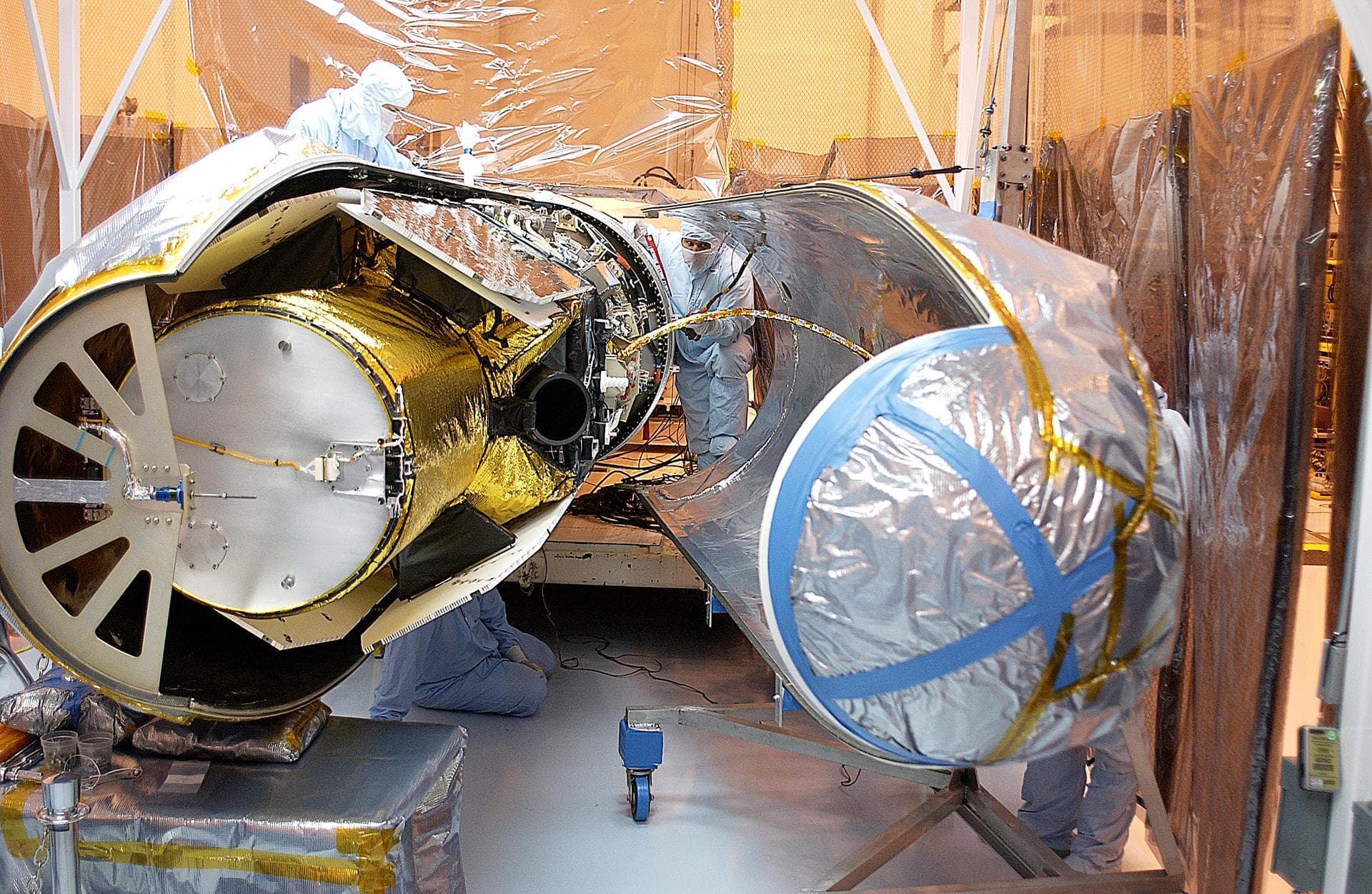 Workers in the Multi-Payload Processing Facility prepare to close the port fairing around the Galaxy Evolution Explorer (GALEX). The spacecraft is already mated to the Pegasus launch vehicle. After en