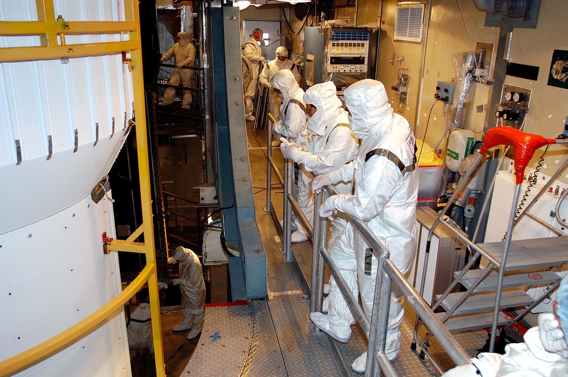 KENNEDY SPACE CENTER, FLA. - In the mobile service tower on Launch Pad 17-B, Cape Canaveral Air Force Station, workers watch as the first half of the fairing moves closer around the Space Infrared Te