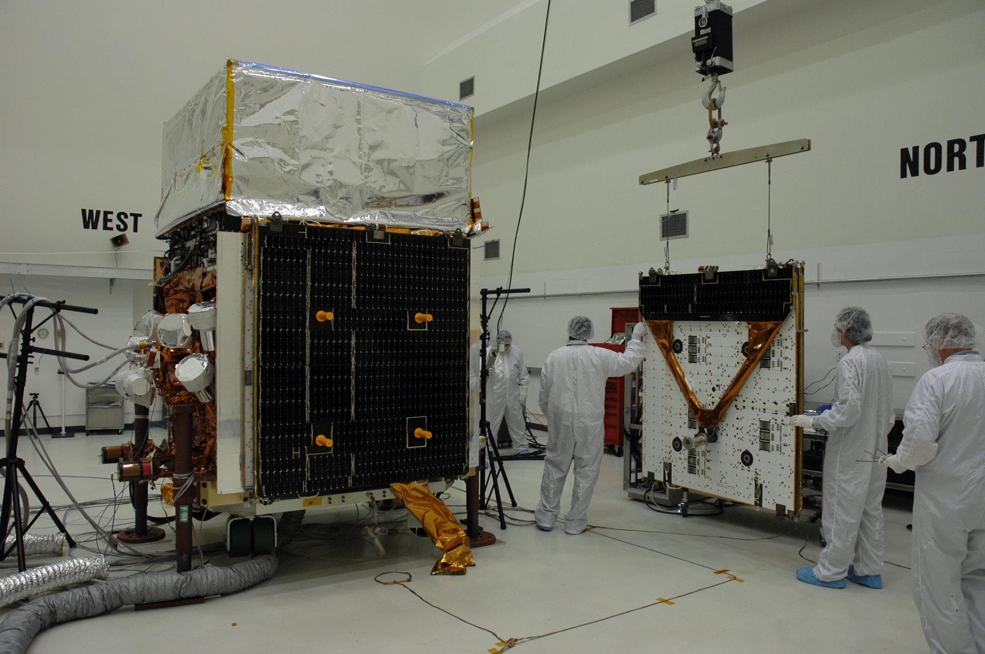 KENNEDY SPACE CENTER, FLA. - In the Astrotech payload processing facility, General Dynamics technicians move the second of twin solar arrays toward NASA's Gamma-Ray Large Area Space Telescope, or GLA