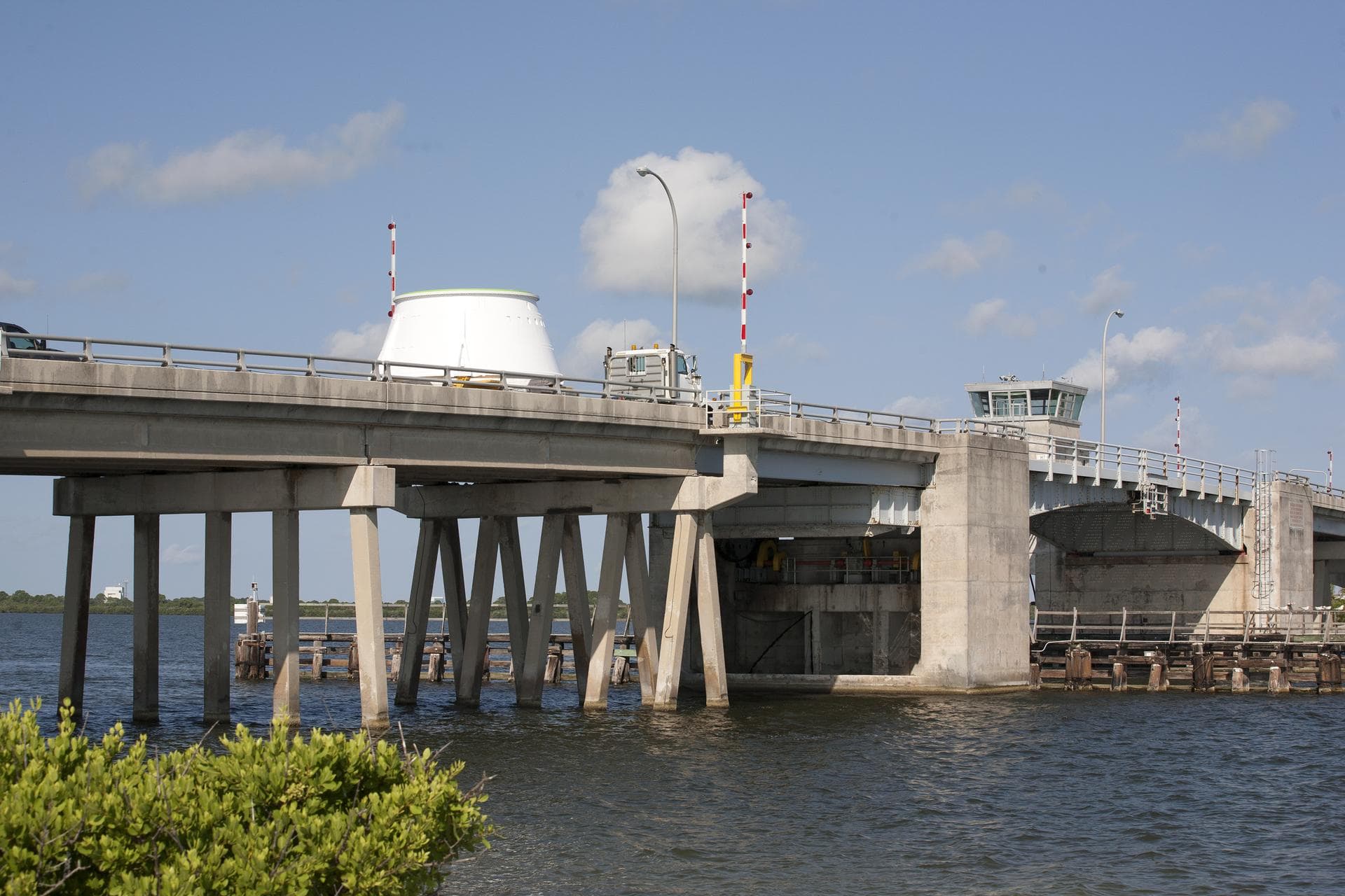 The left hand aft skirt for NASA’s Space Launch System (SLS) rocket is transported across the Roy D. Bridges Bridge from the Hangar AF facility at Cape Canaveral Air Force Station in Florida, on its w