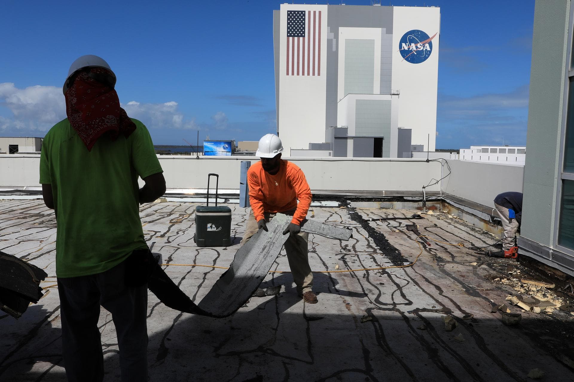 Members of the Disaster Assessment and Recovery Team (DART) repair a section of roof atop the Operations Support Building II at NASA’s Kennedy Space Center in Florida. The effort is part of the space