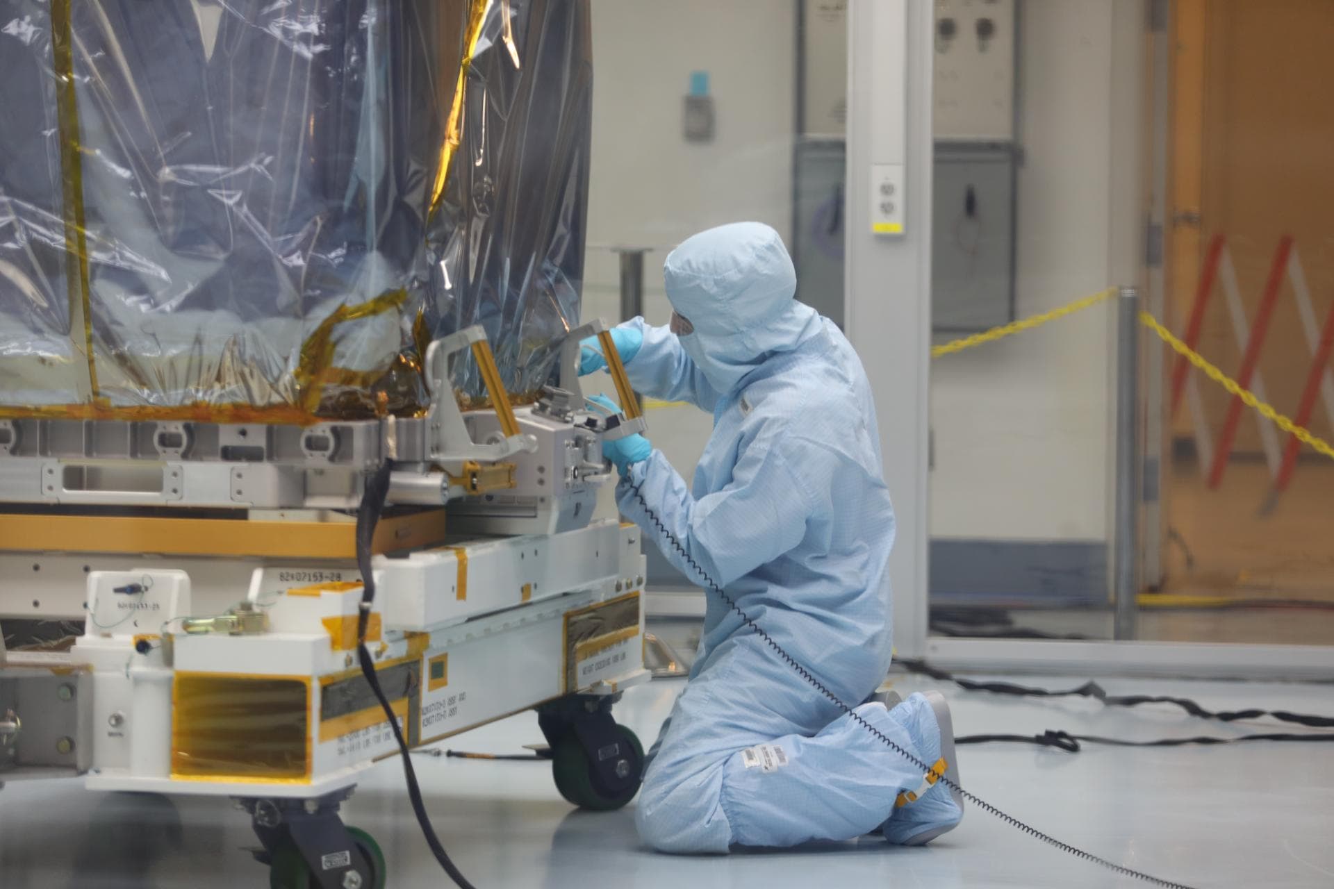 Inside the Space Station Processing Facility high bay at NASA's Kennedy Space Center in Florida, a technician prepares the Neutron star Interior Composition Explorer, or NICER, payload for final packa