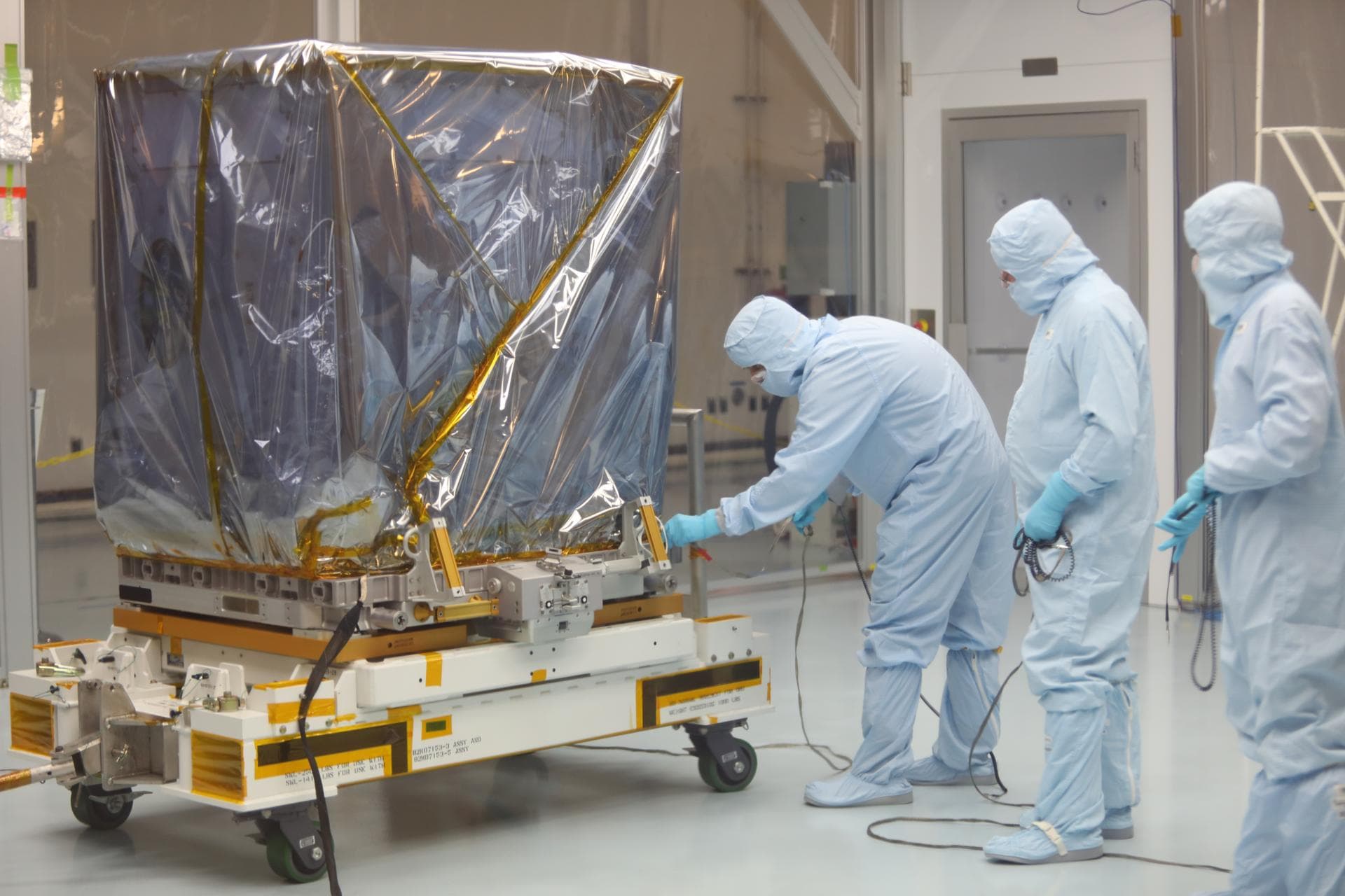 Inside the Space Station Processing Facility high bay at NASA's Kennedy Space Center in Florida, technicians prepare the Neutron star Interior Composition Explorer, or NICER, payload for final packagi