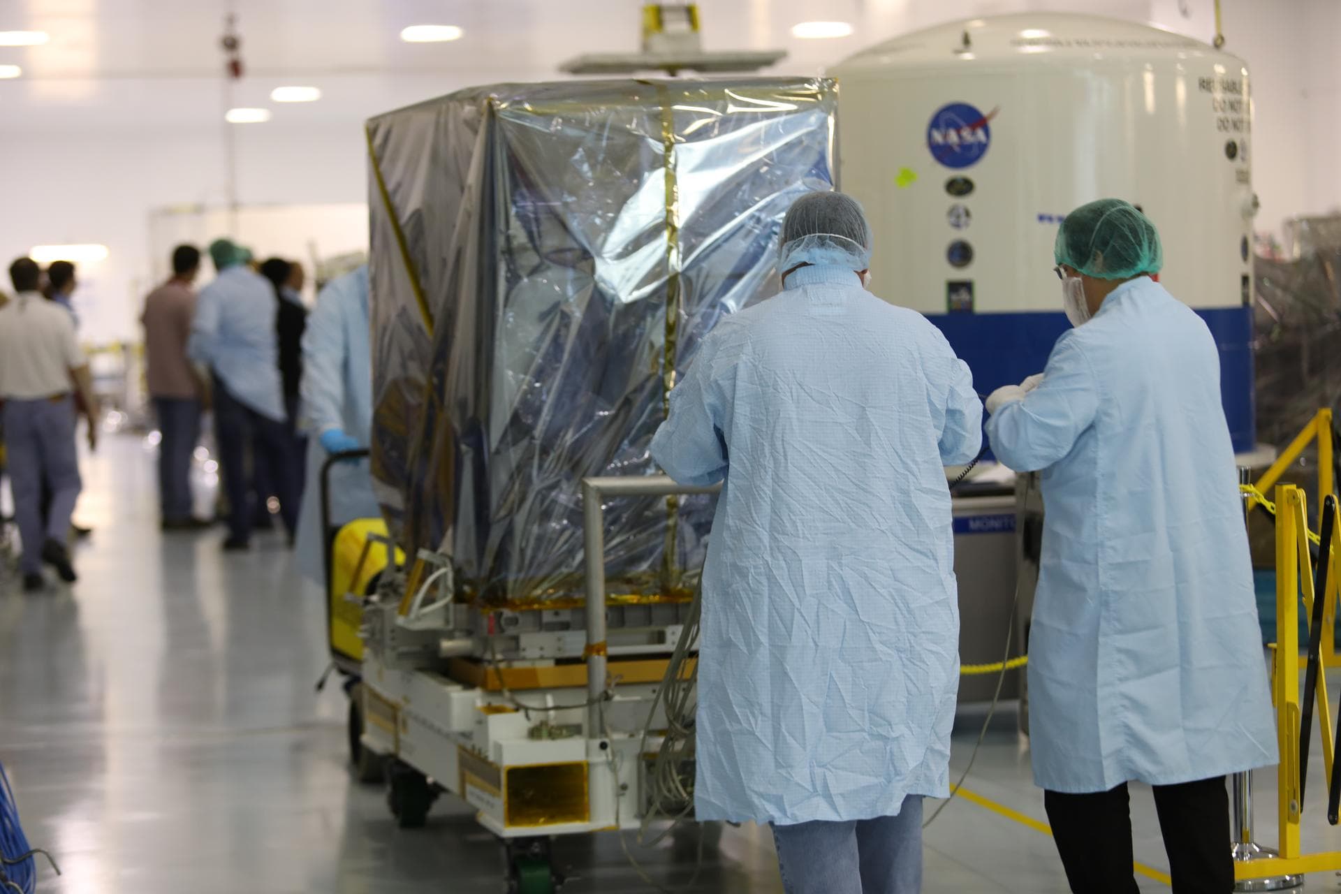 Inside the Space Station Processing Facility high bay at NASA's Kennedy Space Center in Florida, technicians prepare the Neutron star Interior Composition Explorer, or NICER, payload for final packagi