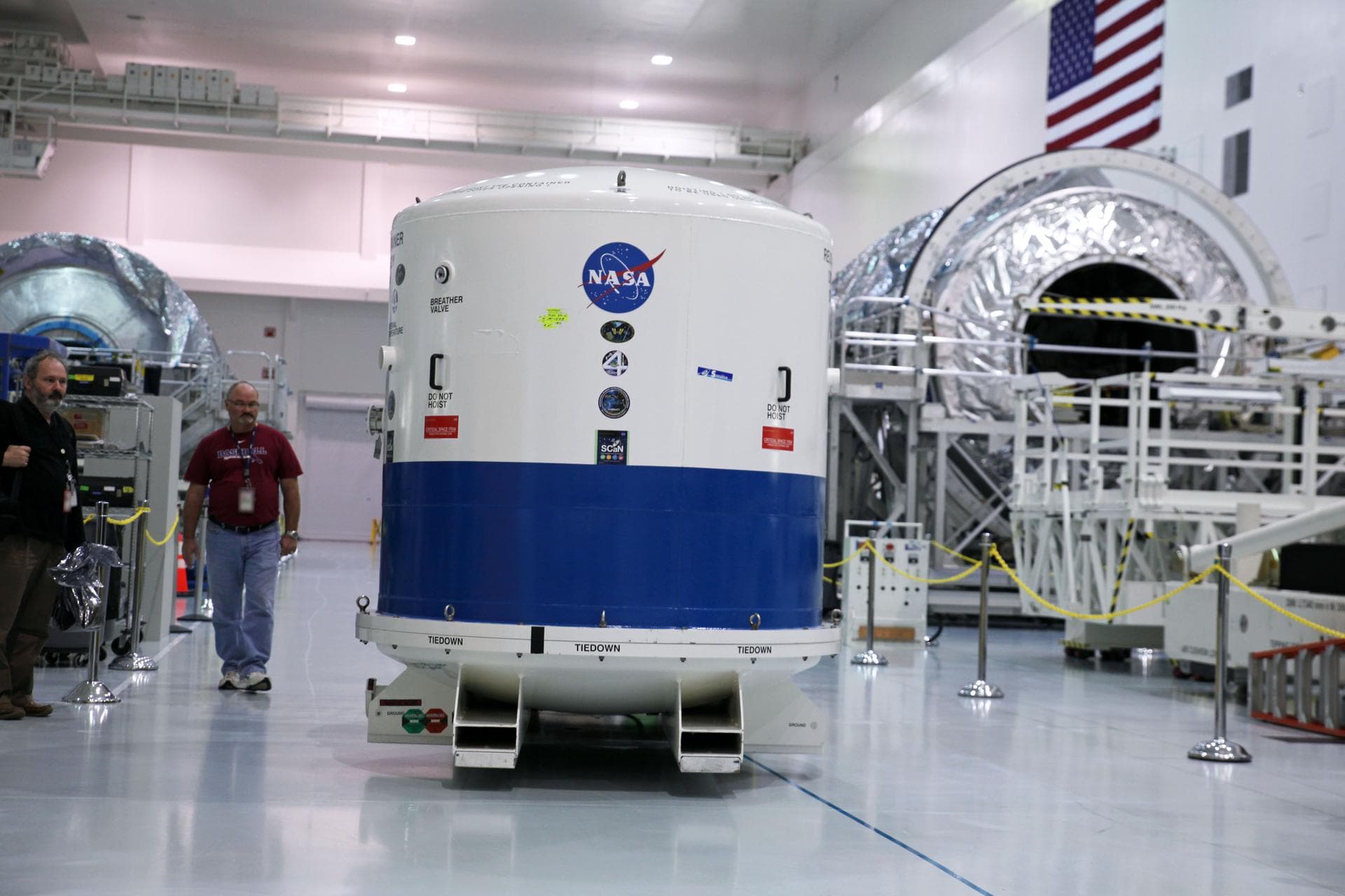 Inside the Space Station Processing Facility high bay at NASA's Kennedy Space Center in Florida, the Neutron star Interior Composition Explorer, or NICER, payload is secured inside a protective contai