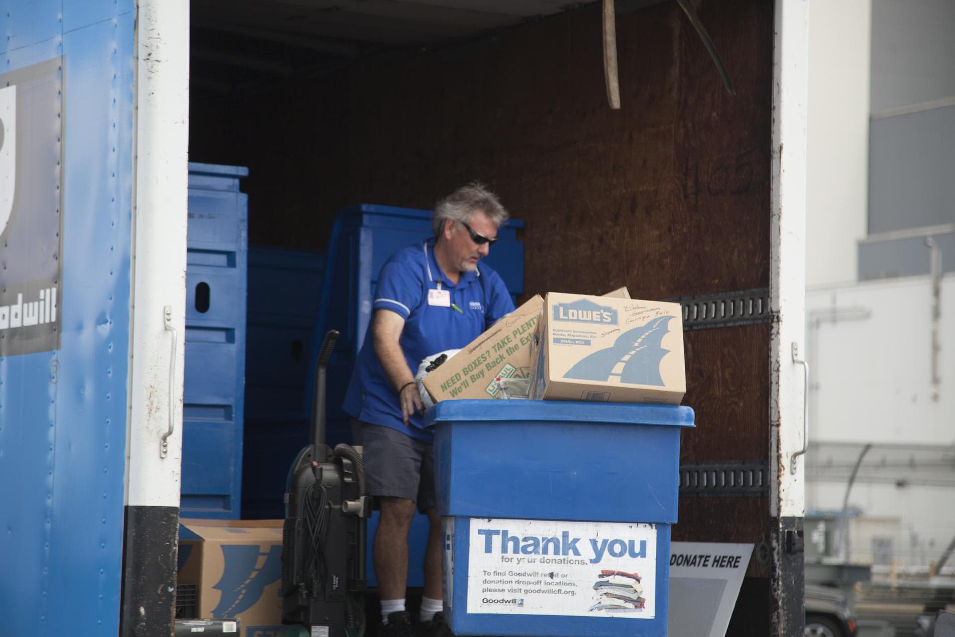 In the parking lot of the Vehicle Assembly Building at NASA's Kennedy Space Center in Florida, a member of Goodwill Industries loads used household material for recycling. During the two-day event, em