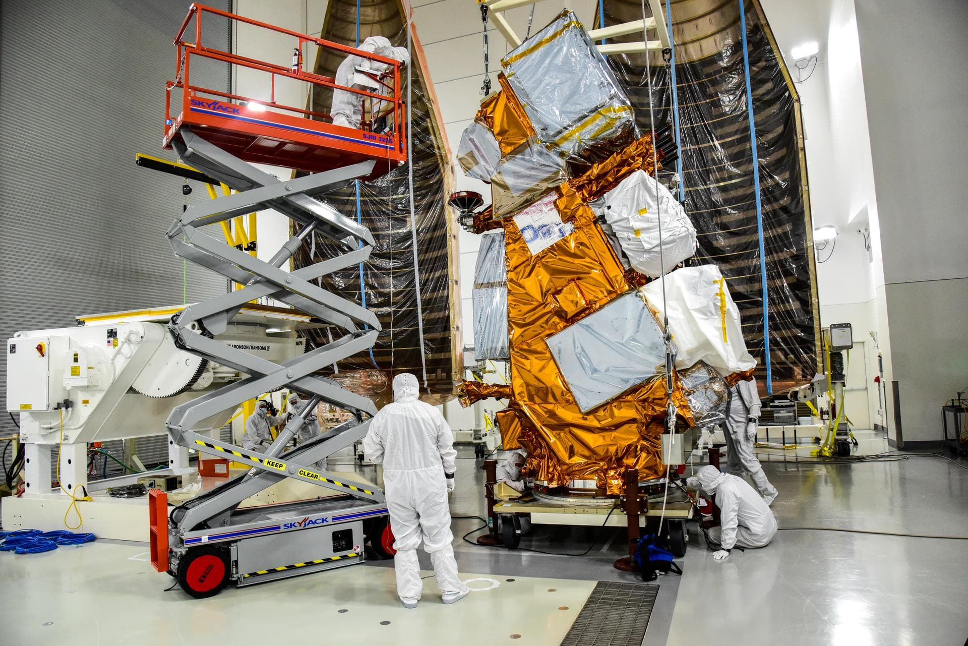 Technicians help transfer NASA and the National Oceanic and Atmospheric Administration’s (NOAA) Joint Polar Satellite System-2 (JPSS-2) satellite onto an integration and testing cart inside the Astrot