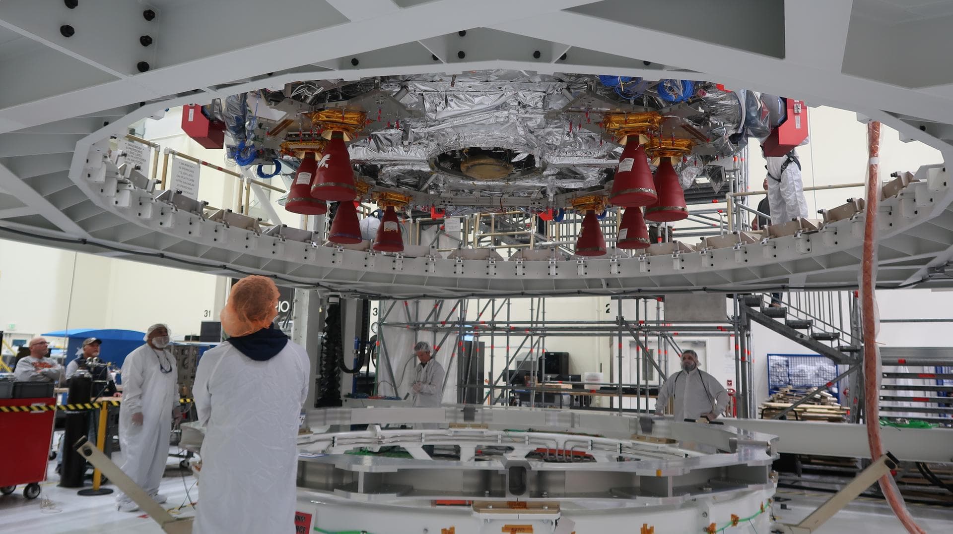Technicians at NASA’s Kennedy Space Center in Florida begin installing the orbital maneuvering system engine nozzle and heat shield for the Artemis II European Service Module inside the Neil Armstrong