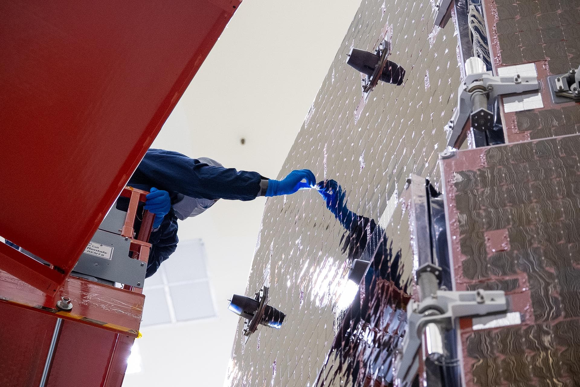 Technicians and engineers inside the Payload Hazardous Servicing Facility at NASA’s Kennedy Space Center in Florida clean and inspect the Solar Array Sun Shield (SASS) on the agency’s Nancy Grace Roma
