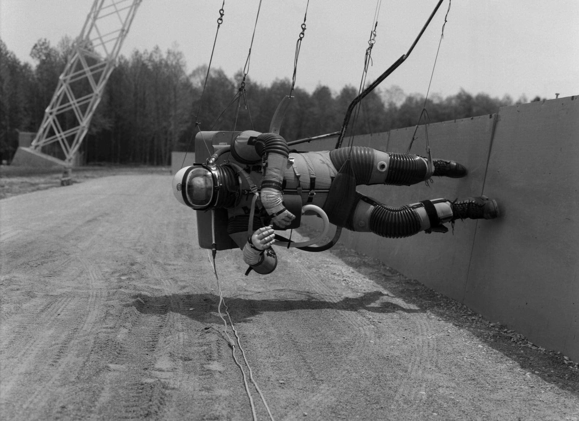Test subject wearing the pressurized "space" suit for the Reduced Gravity Walking Simulator located at the Lunar Landing Facility. The purpose of this simulator was to study the subject while walking,