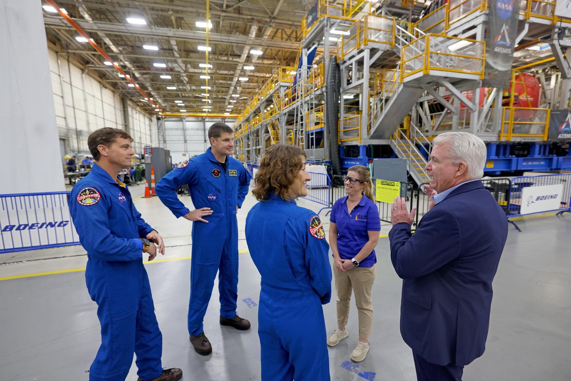 Artemis II NASA astronauts Reid Wiseman and Christina Koch of NASA and CSA (Canadian Space Agency) astronaut Jeremy Hansen view the core stage for the SLS (Space Launch System) rocket at the agency’s