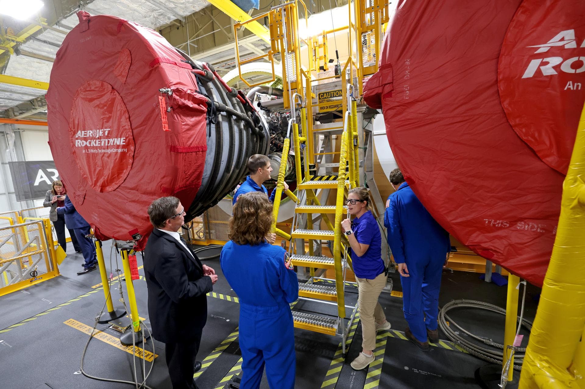 Artemis II NASA astronauts Reid Wiseman and Christina Koch of NASA and CSA (Canadian Space Agency) astronaut Jeremy Hansen view the core stage for the SLS (Space Launch System) rocket at the agency’s