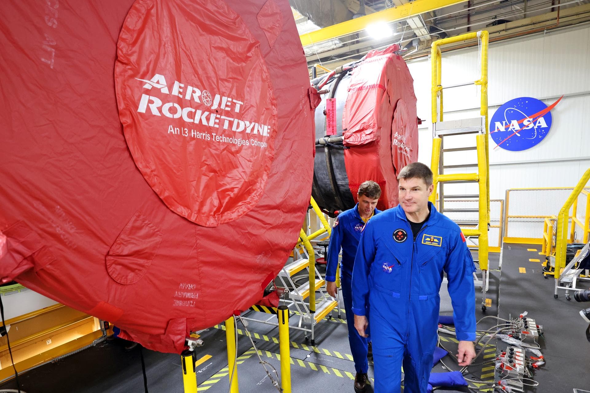 Artemis II NASA astronauts Reid Wiseman and Christina Koch of NASA and CSA (Canadian Space Agency) astronaut Jeremy Hansen view the core stage for the SLS (Space Launch System) rocket at the agency’s