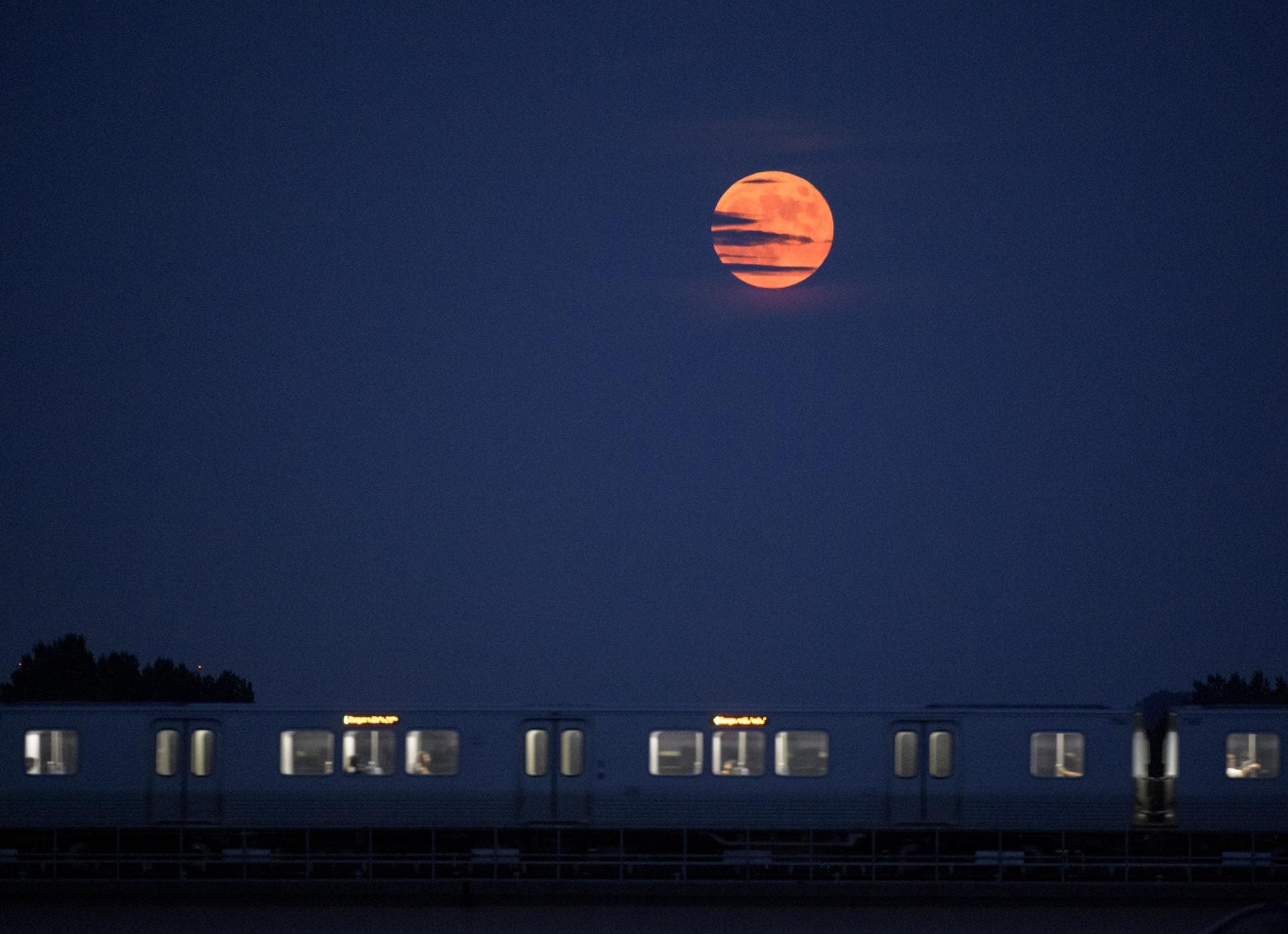 The Moon rises as a Metrorail car crosses the Potomac river in Washington 50 years to the day after astronauts Neil Armstrong, Michael Collins, and Buzz Aldrin launched on Apollo 11, the first mission