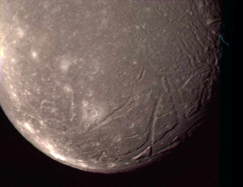 On Jan. 24, 1986, NASA Voyager 2 obtained this color picture of the Uranian moon, Ariel. Most of the visible surface consists of relatively intensely cratered terrain transected by fault scarps and fa