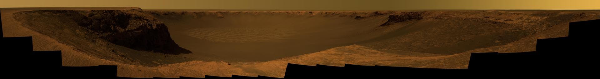 NASA Mars Exploration Rover Opportunity captured this vista of Victoria Crater from the viewpoint of Cape Verde, one of the promontories that are part of the scalloped rim of the crater.